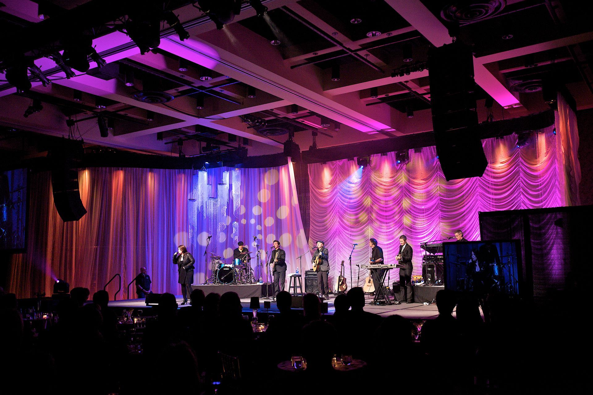 A group of people are standing on a stage in front of a crowd.