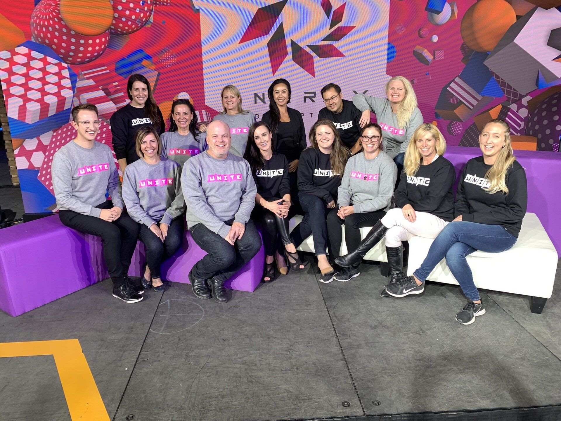 A group of people are posing for a picture while sitting on a couch.