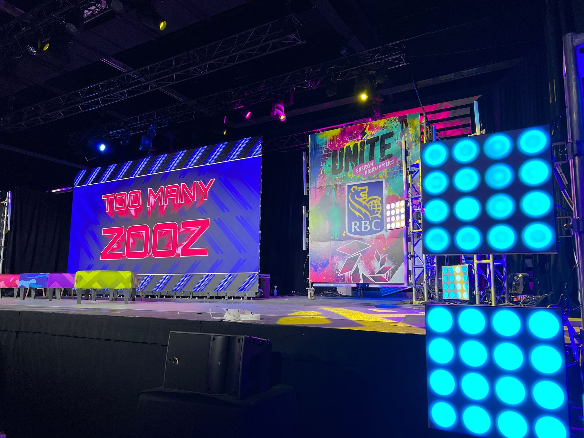 A stage with a lot of lights on it and a large screen.