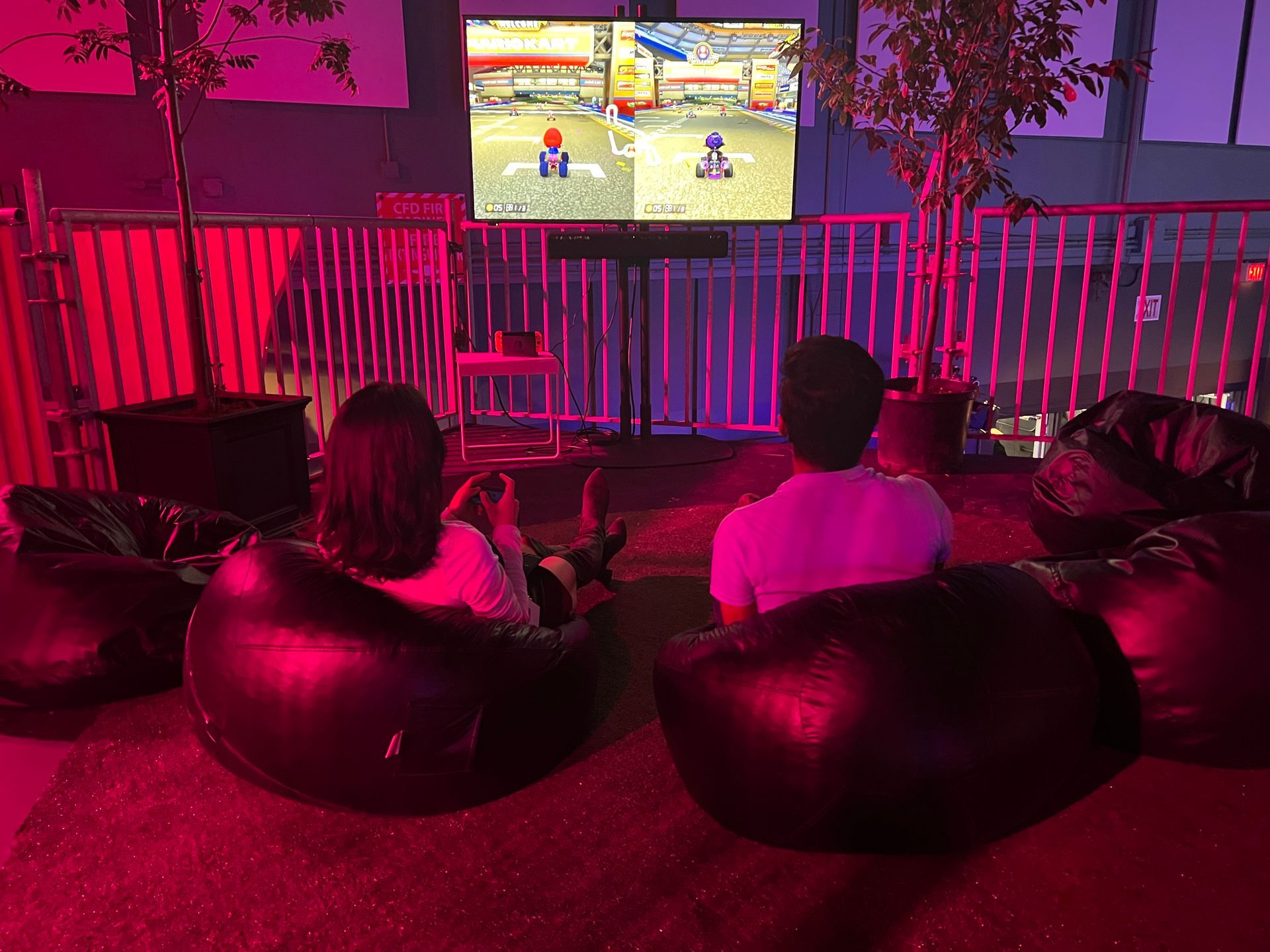 A man and a woman are sitting in bean bag chairs playing a video game.