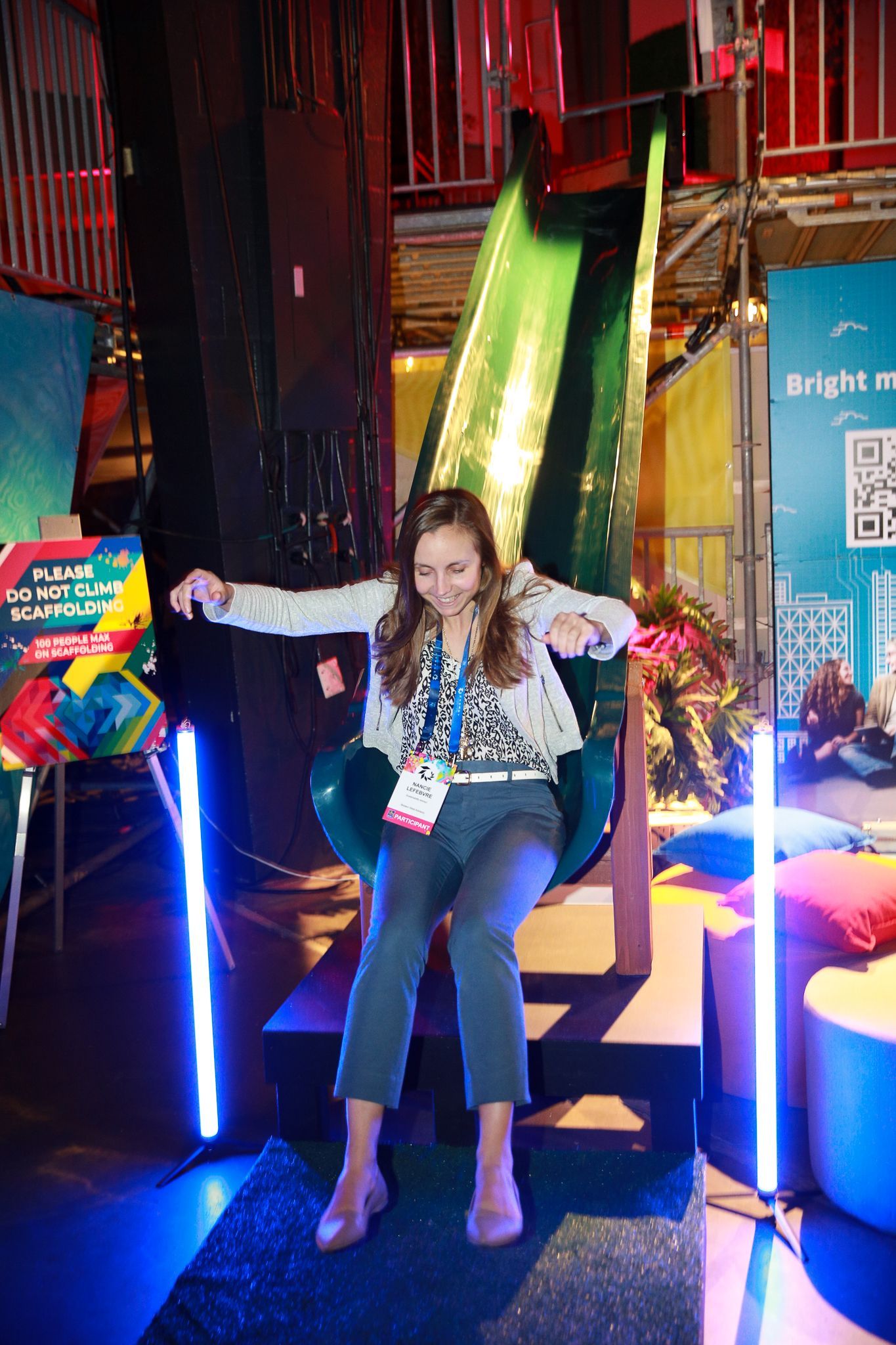 A woman is sitting on a chair in front of a slide.