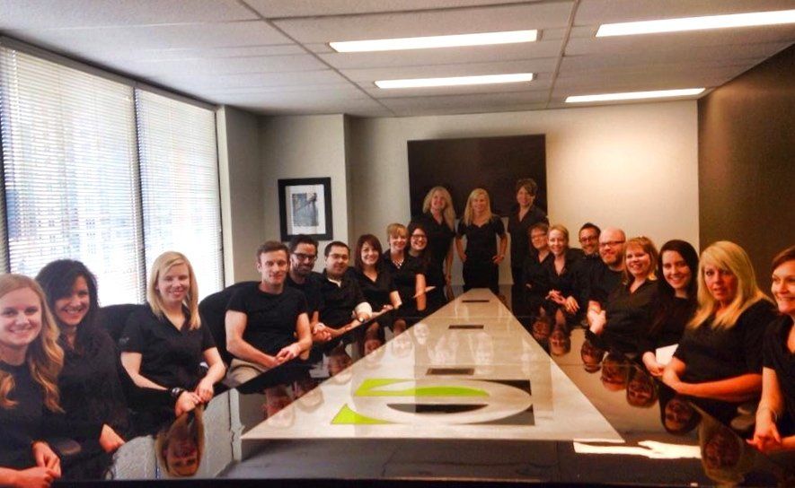 A group of people are sitting around a long table in a conference room.