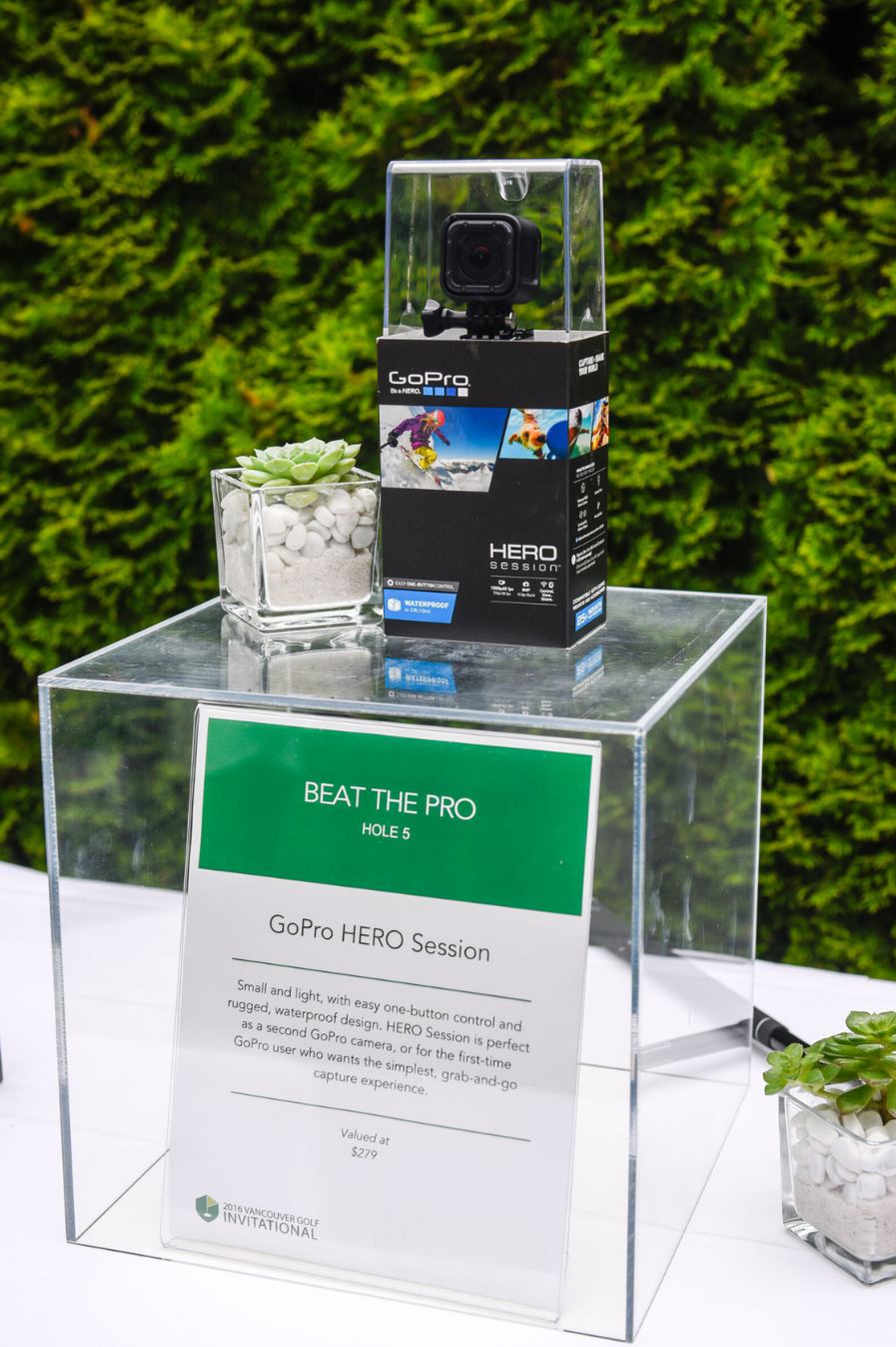 A gopro camera is sitting on top of a clear cube on a table.