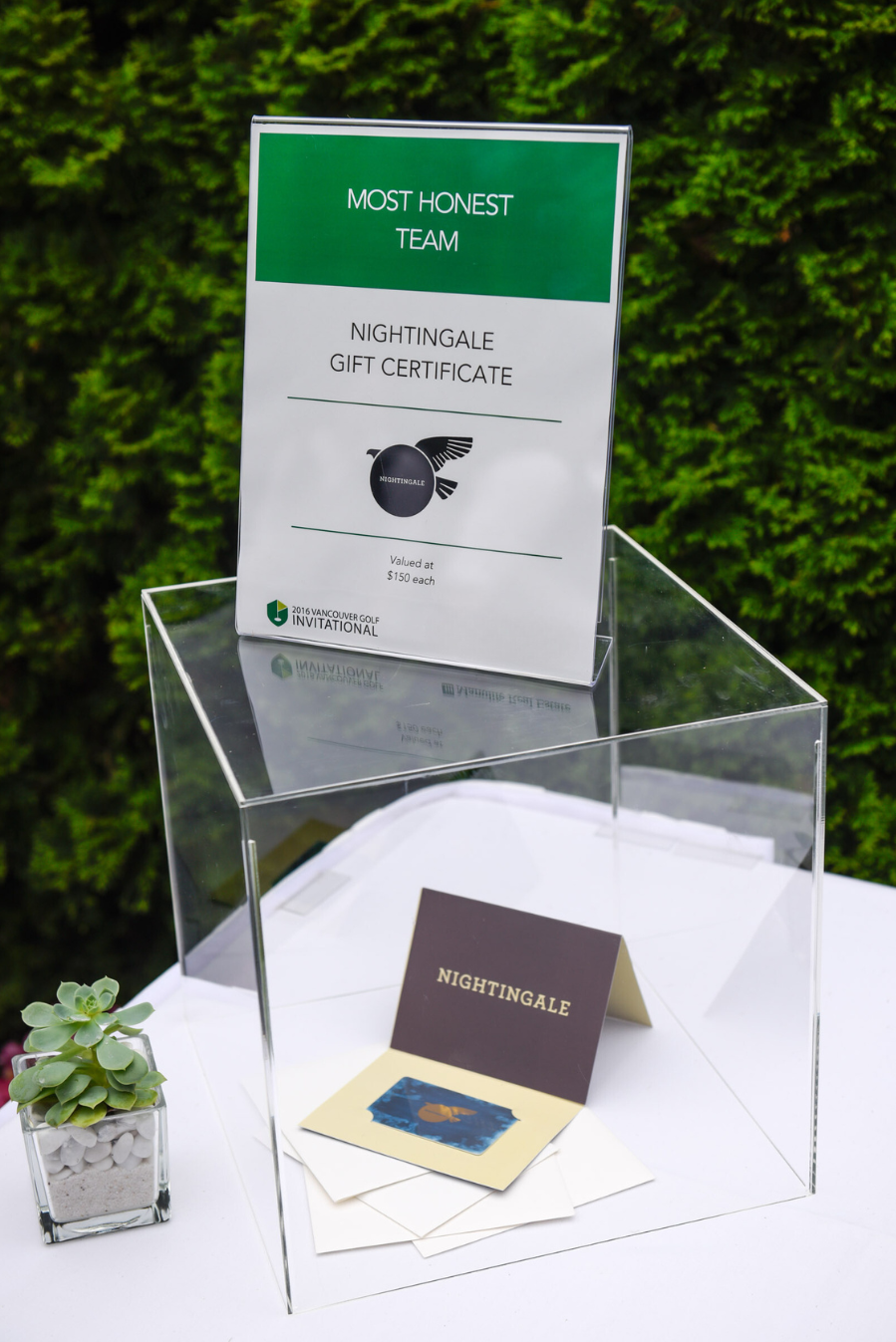 A clear acrylic box with a sign on top of it