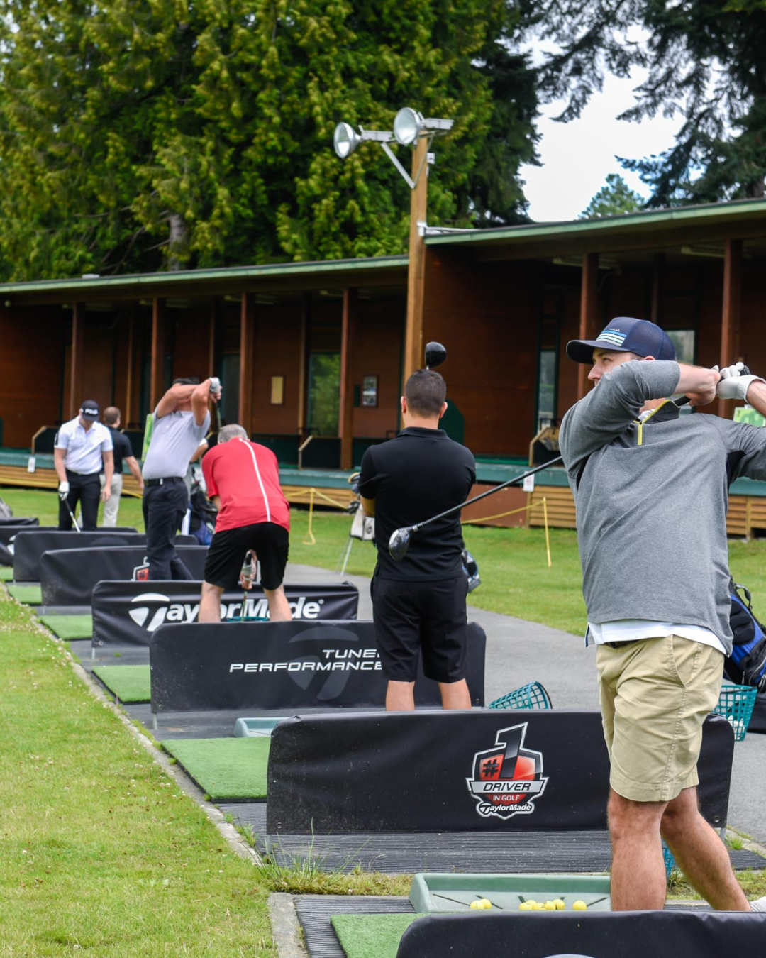 A group of men are practicing golf at a taylormade golf course