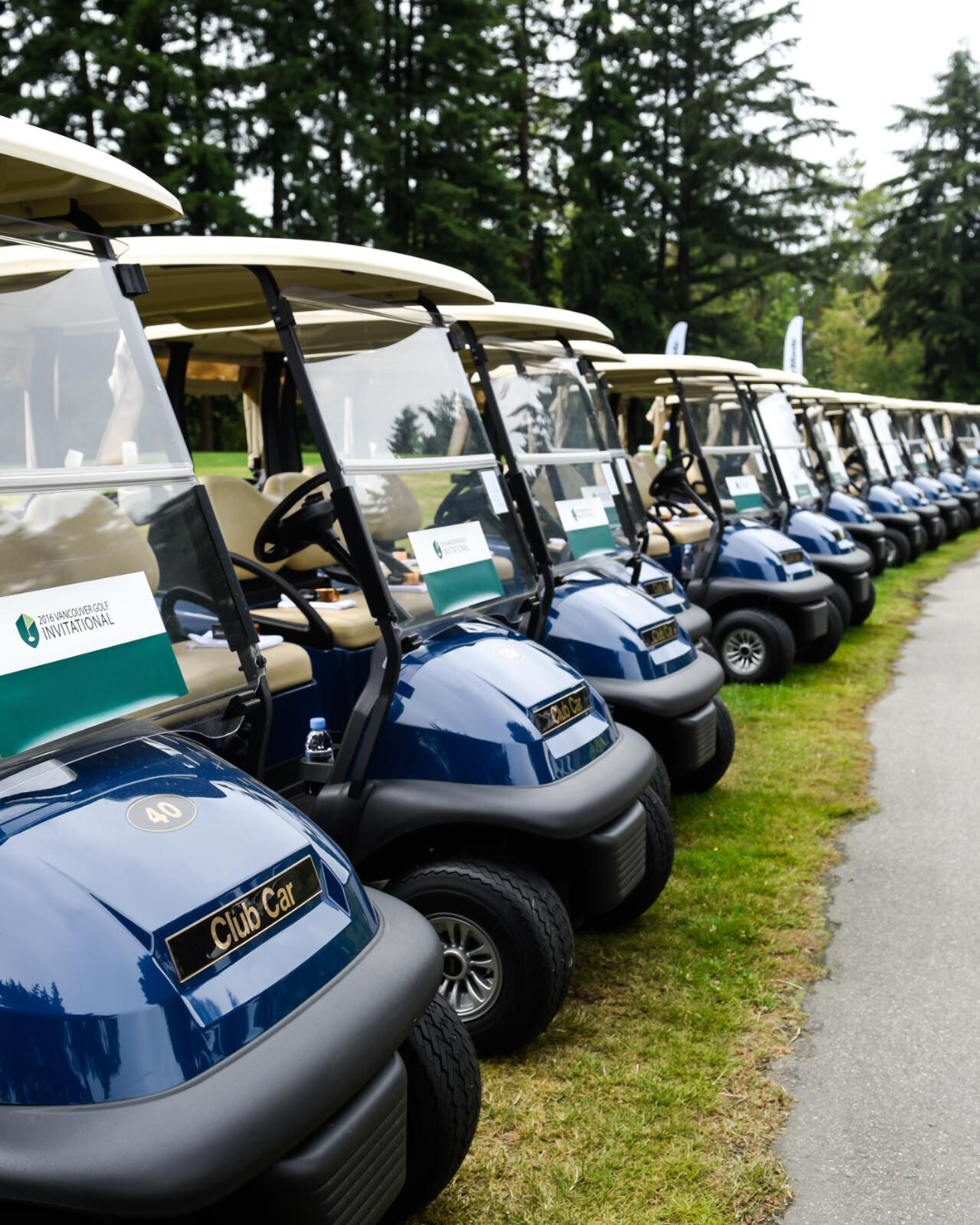 A row of golf carts are parked next to each other
