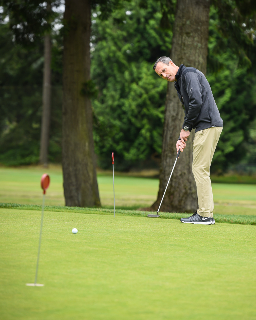 A man is putting a golf ball on a green.