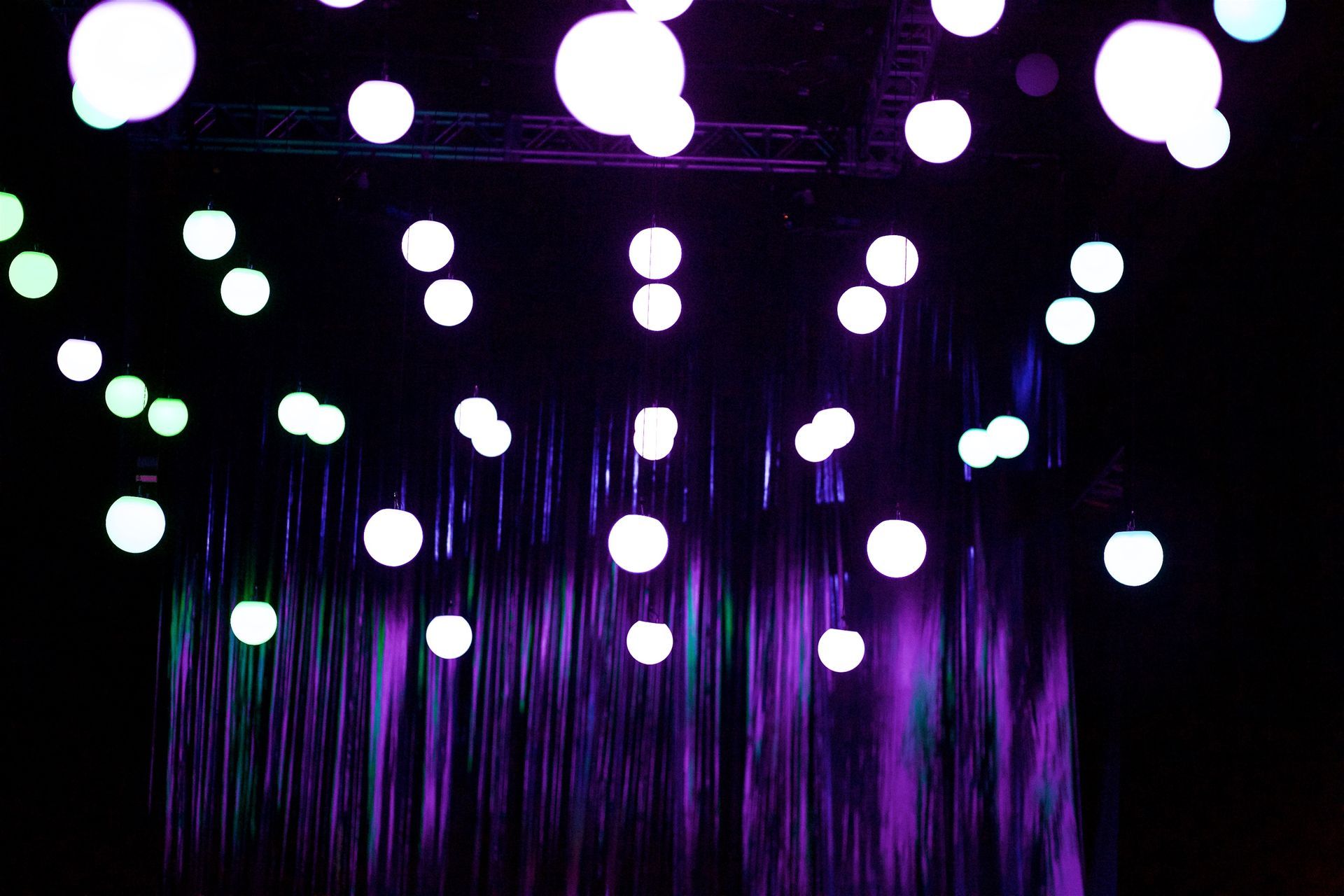 A bunch of lights are hanging from the ceiling in a dark room.