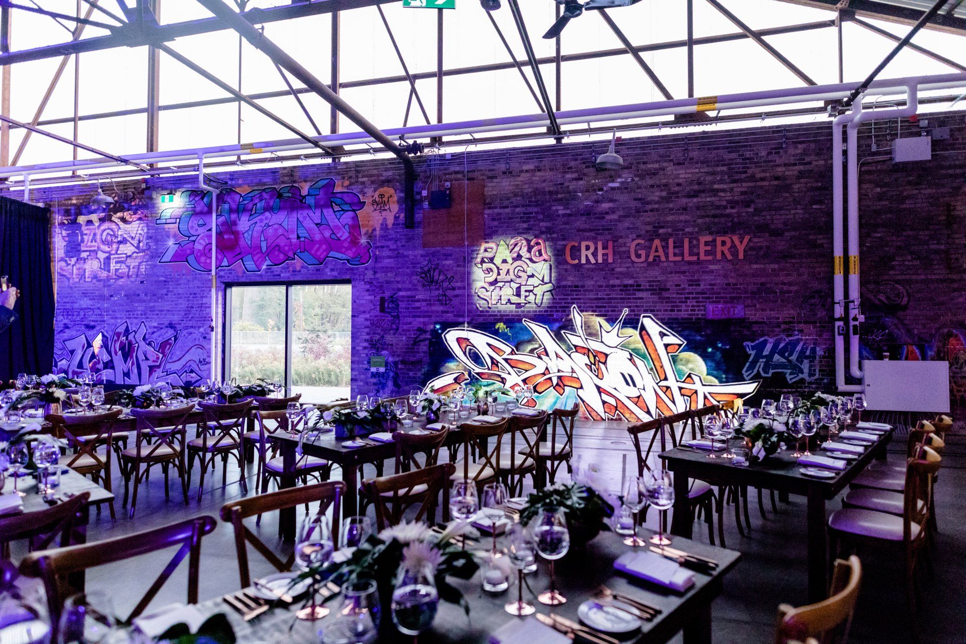 A large room with tables and chairs set up for a wedding reception.