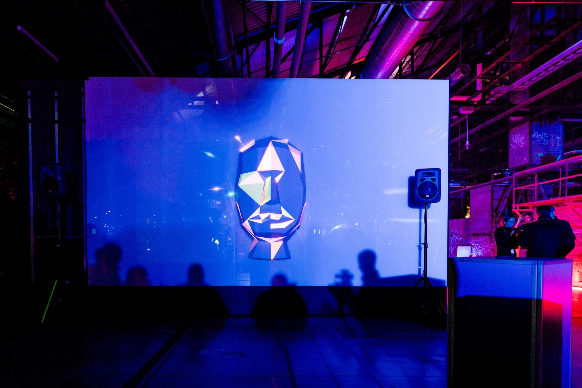 A large screen with a picture of a face on it in a dark room.