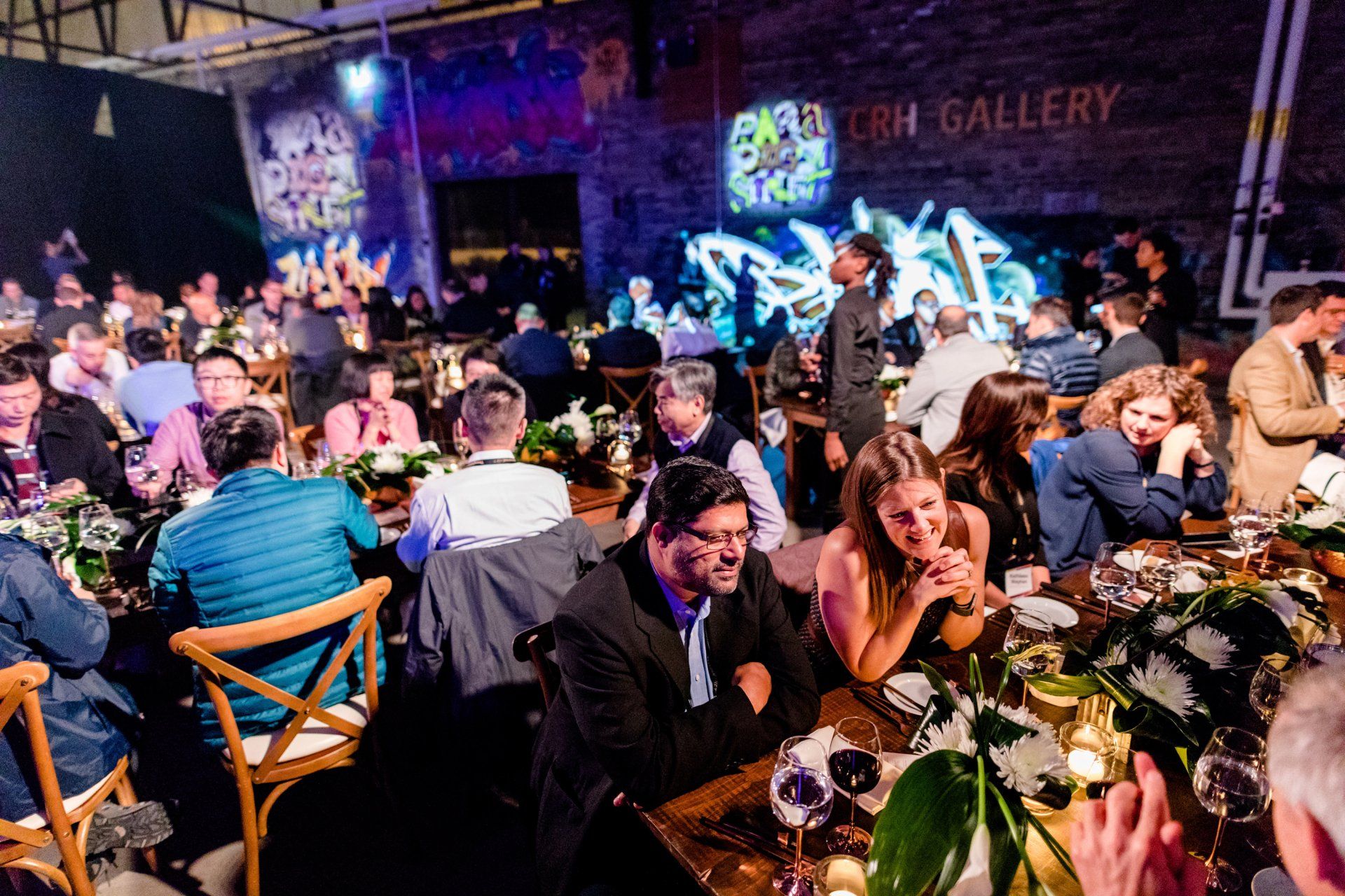 A large group of people are sitting at tables in a restaurant.