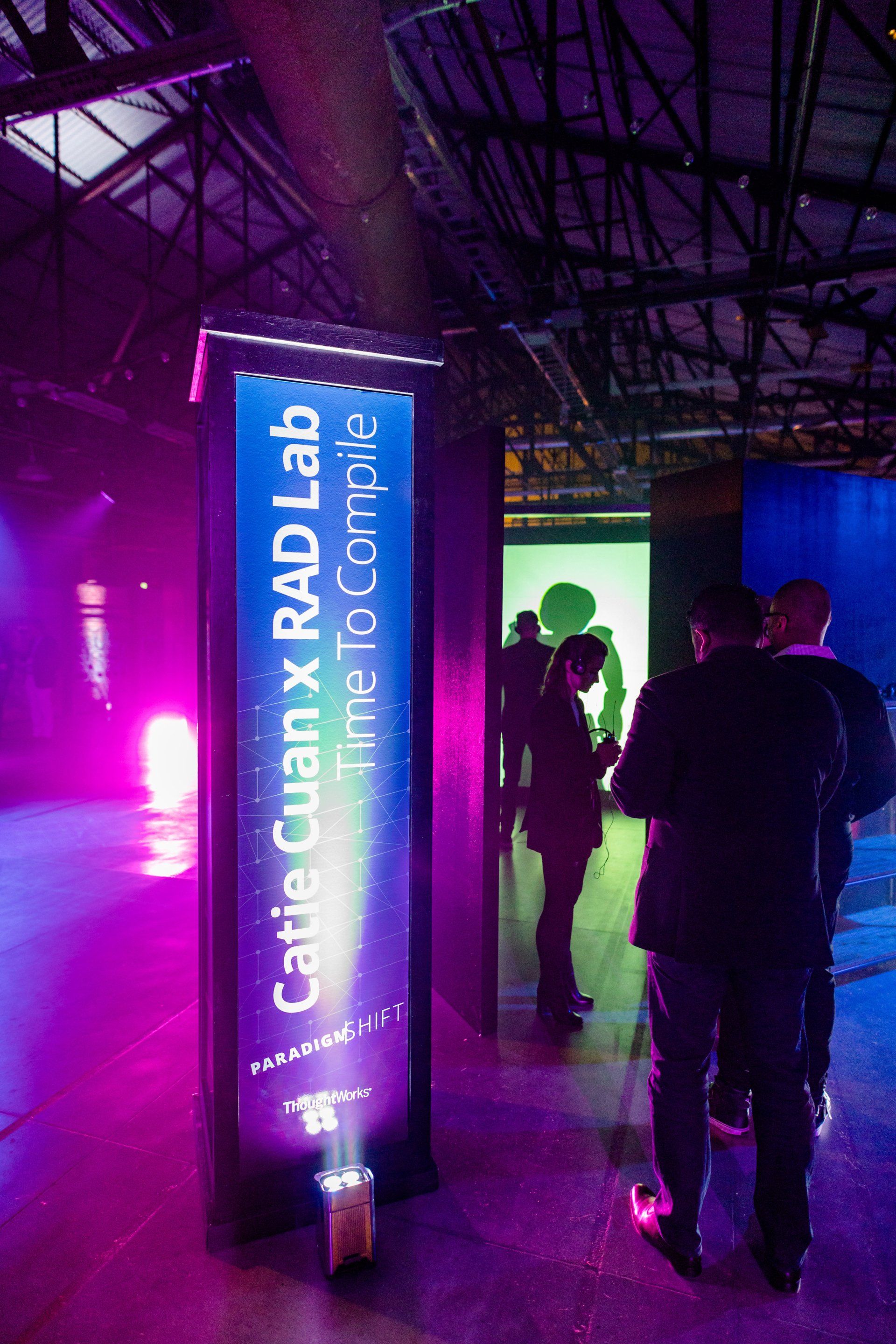 A group of people standing in front of a sign that says catie guan x rad lab