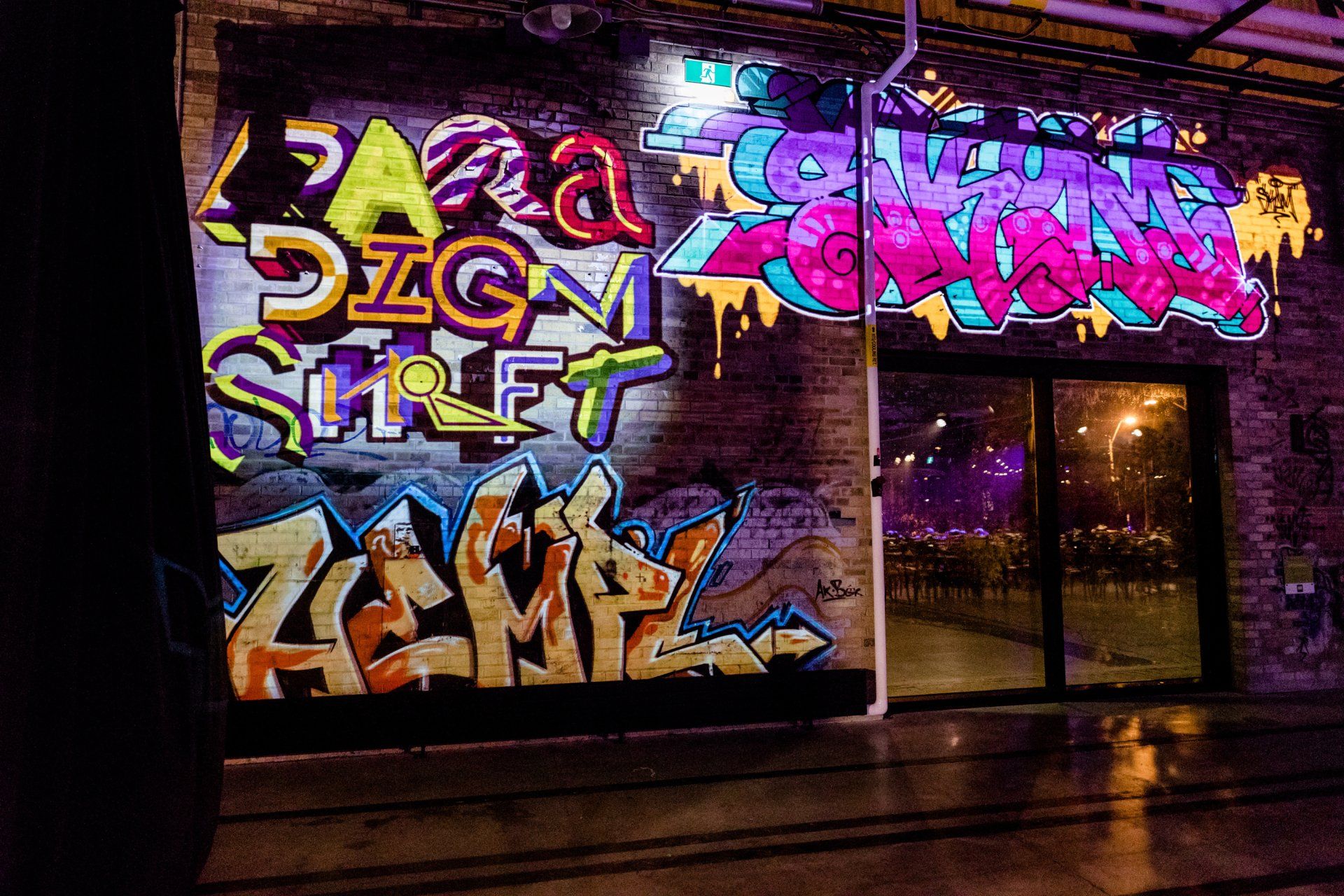 A brick building with graffiti on the side of it and a sign that says dzgn street.