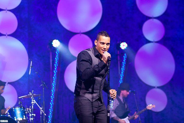 A man is singing into a microphone on a stage.