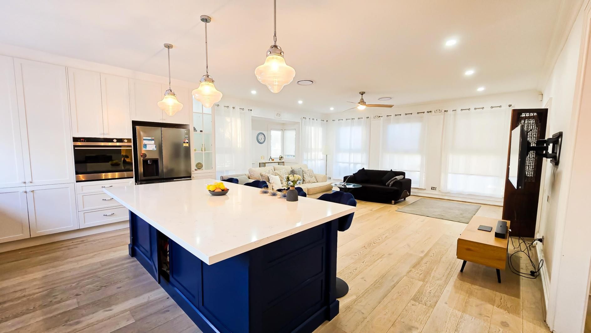 A Kitchen With A Blue Island And White Counter Tops In A Living Room — APEX Painting & Maintenance In Primbee, NSW