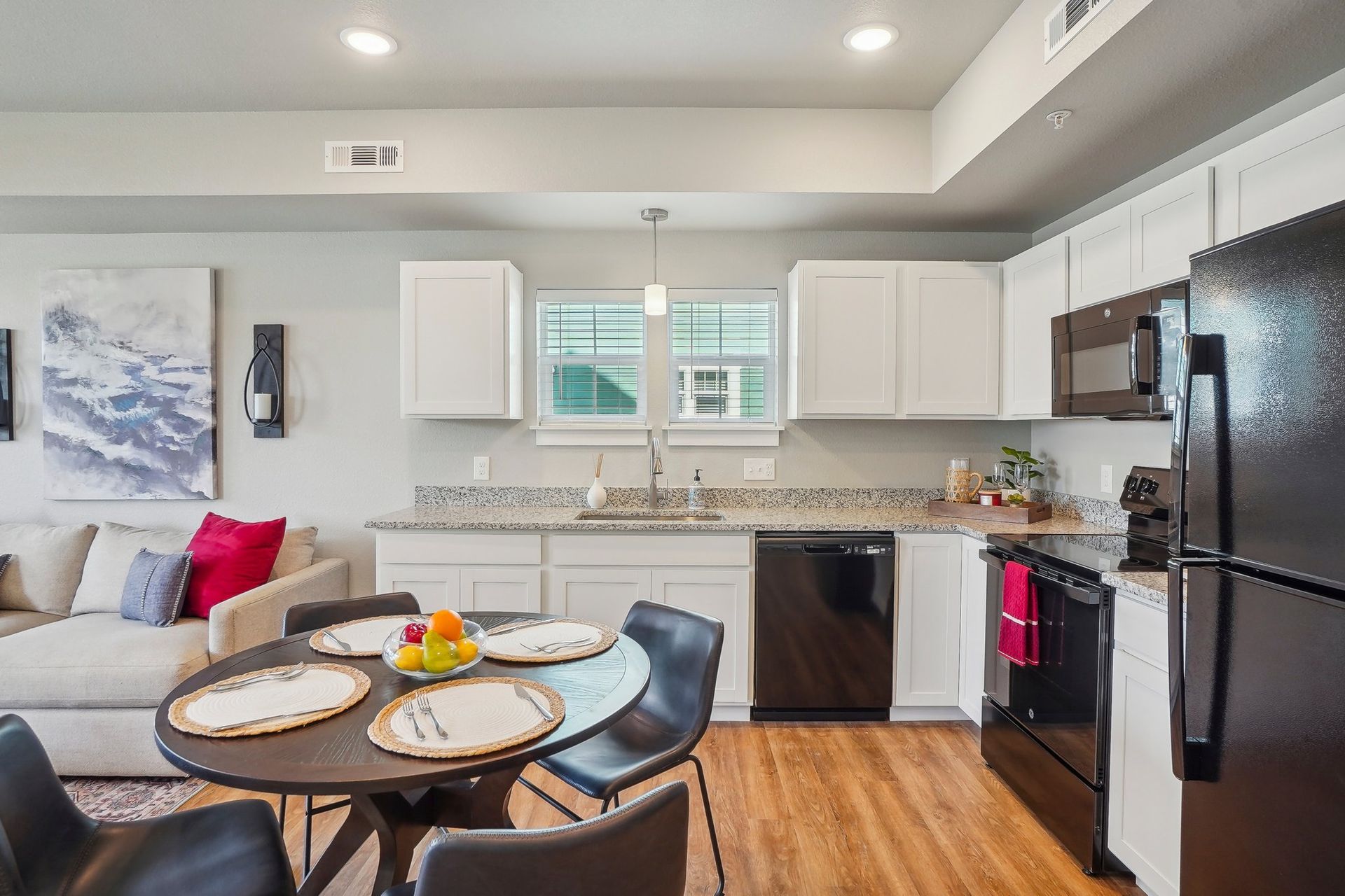 A desk with a laptop , cup of coffee , cell phone and potted plants.