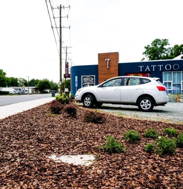 A silver SUV parked in front of a blue building with a 