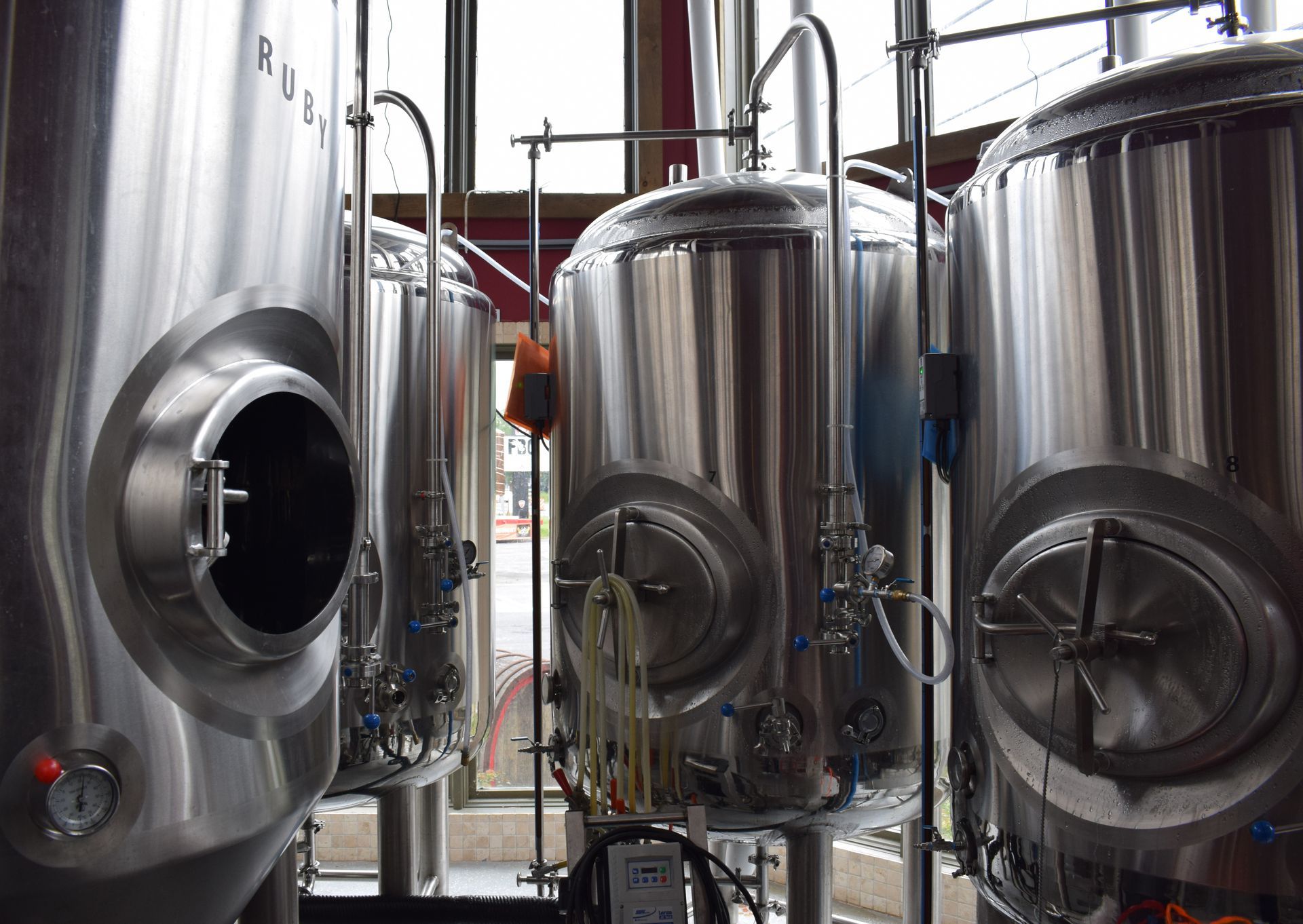 A row of stainless steel tanks in a brewery.