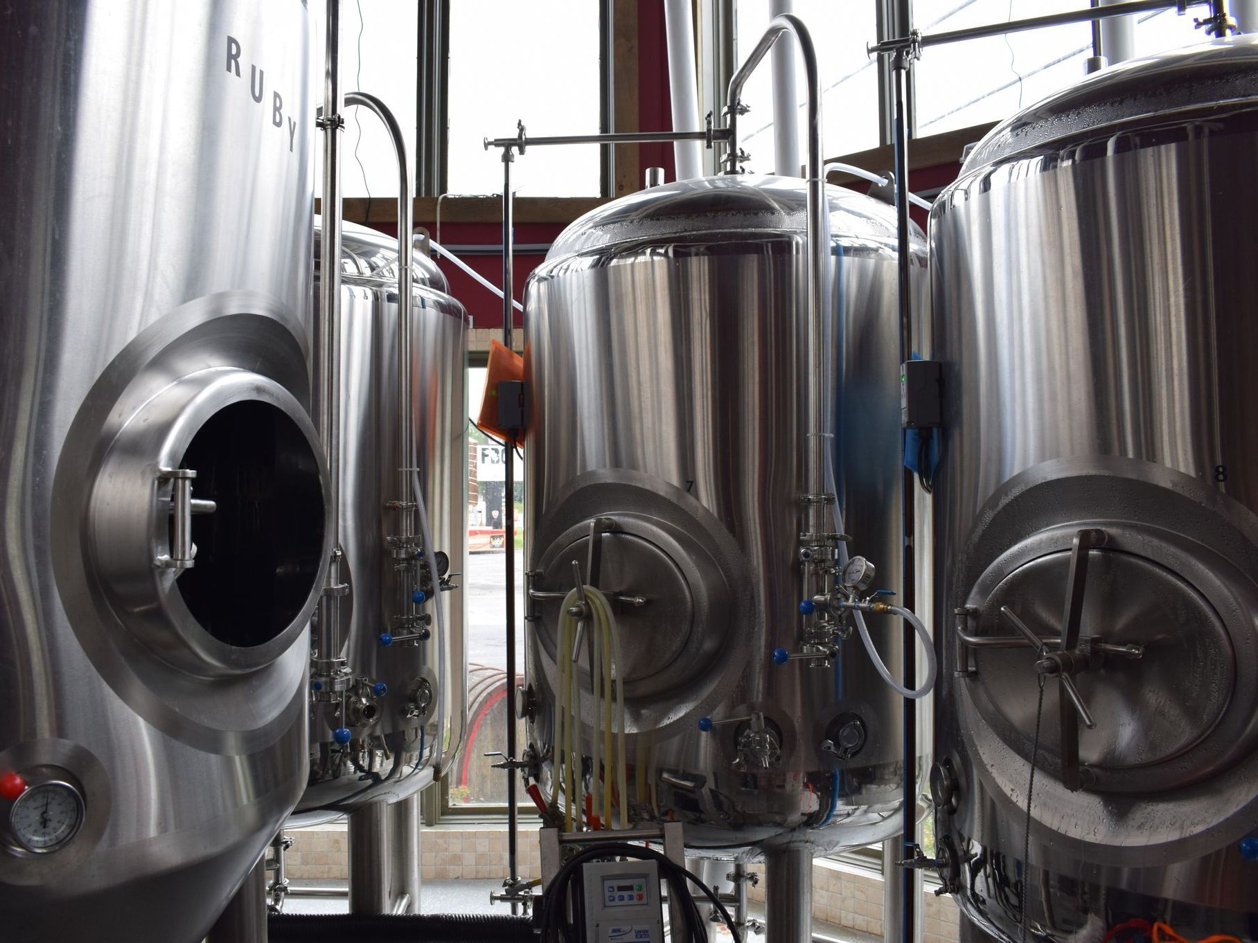 A row of stainless steel tanks in a brewery.