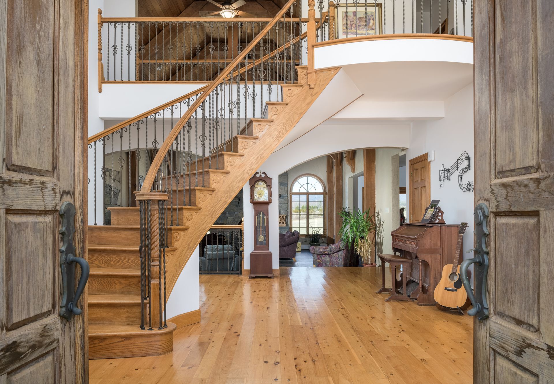 A wooden staircase in a house with a grandfather clock and a piano at at Chestnuthill Countryside Manor
