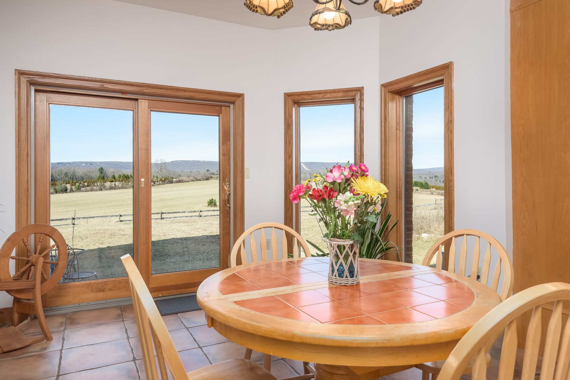 A dining room with a table and chairs and a vase of flowers on the table at Chestnuthill Countryside Manor