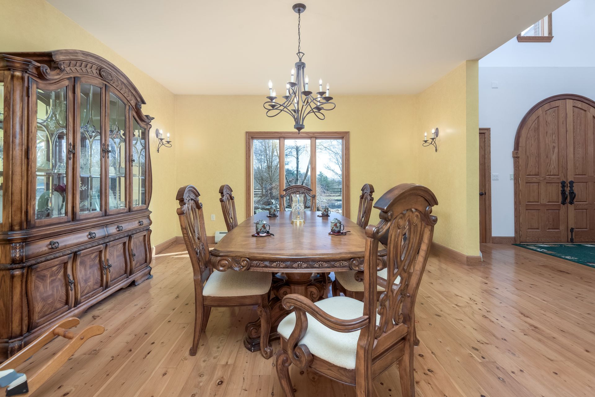 A dining room with a wooden table and chairs and a chandelier hanging from the ceiling at Chestnuthill Countryside Manor