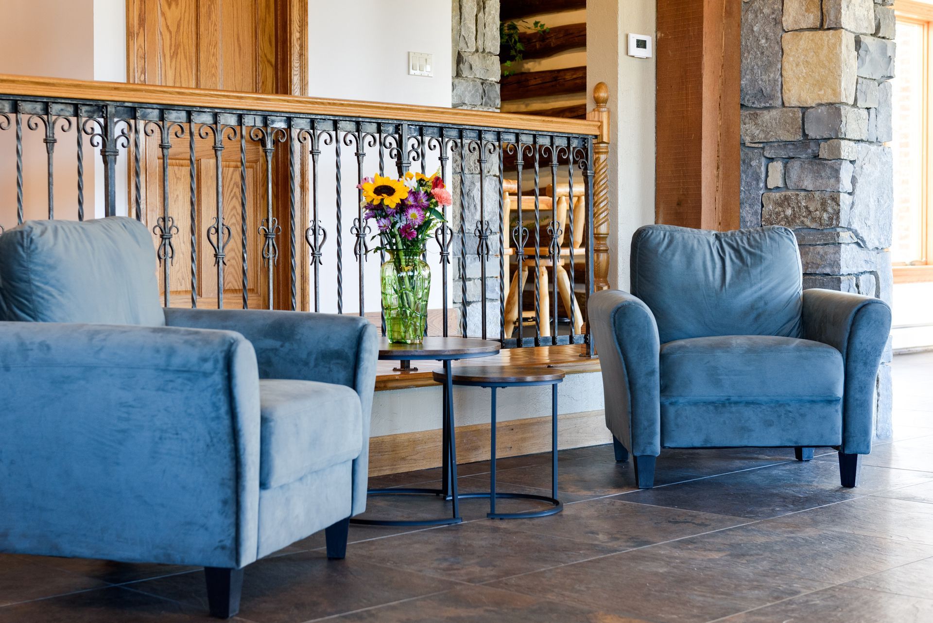 A living room with two chairs and a table with a vase of flowers on it at Chestnuthill Countryside Manor