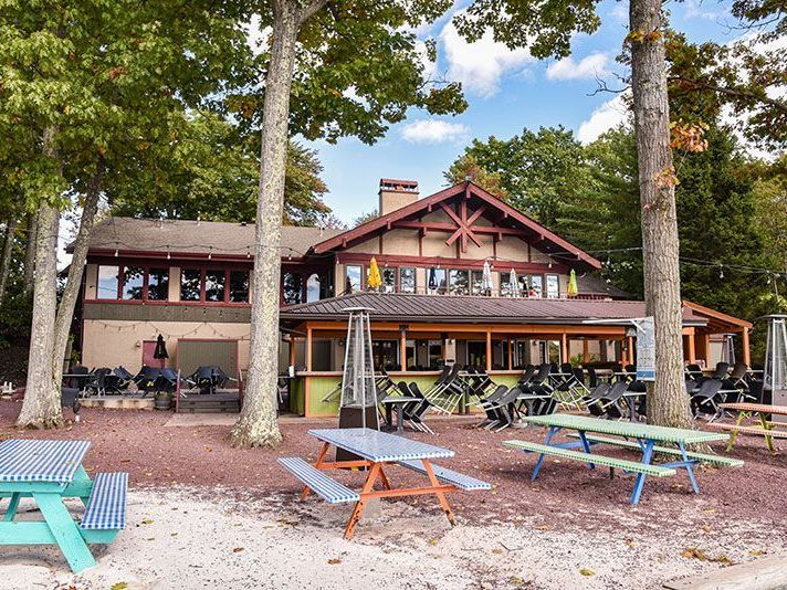 A large building with a lot of picnic tables in front of it.