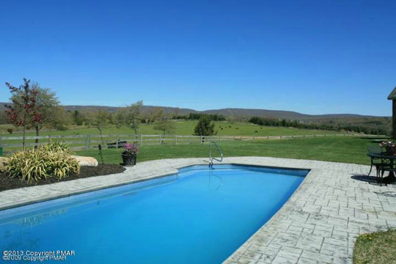 A large swimming pool with mountains in the background at Chestnuthill Countryside Manor