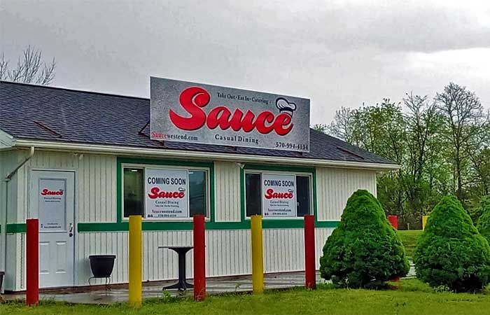 A white building with a sign that says sauce