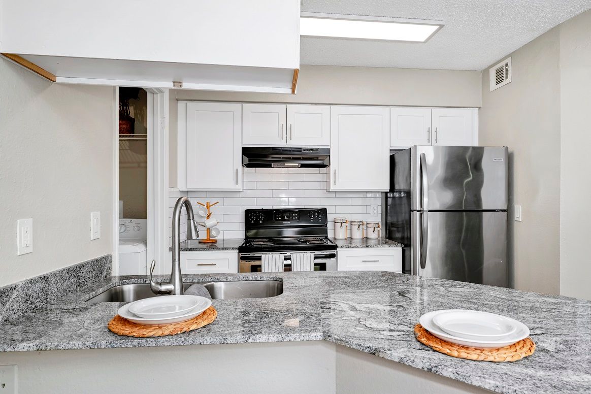 Kitchen with Granite Countertops and a stainless steel refrigerator at The Glades in Altamonte Springs, FL.