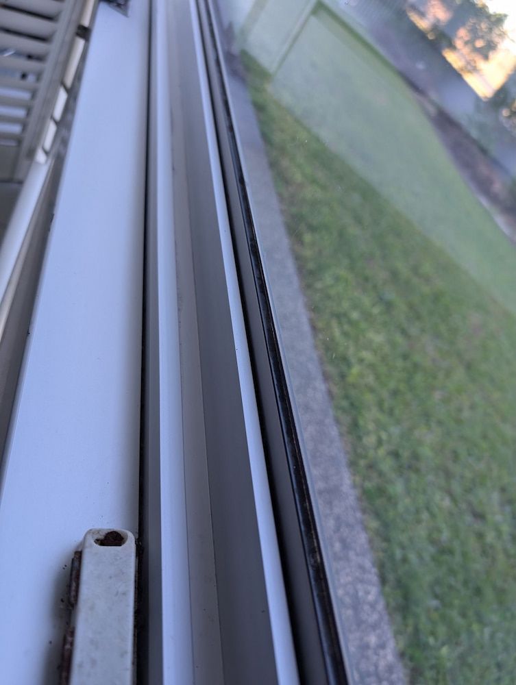A Close-Up of A White Window Frame with A Black Track — Pristine Cleaning Bundaberg In Kalkie, QLD