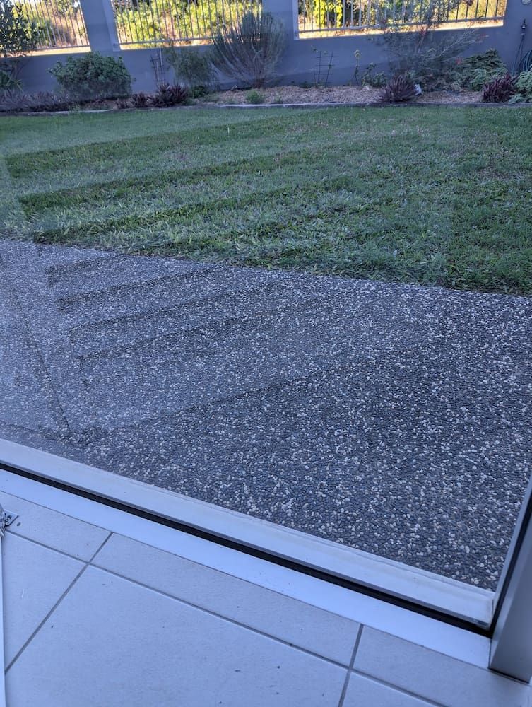 Patio With Dark Textured Surface, Leading to a Green Lawn and Garden — Pristine Cleaning Bundaberg In Kalkie, QLD
