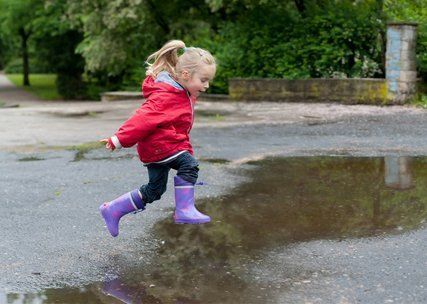 child jumping the puddle