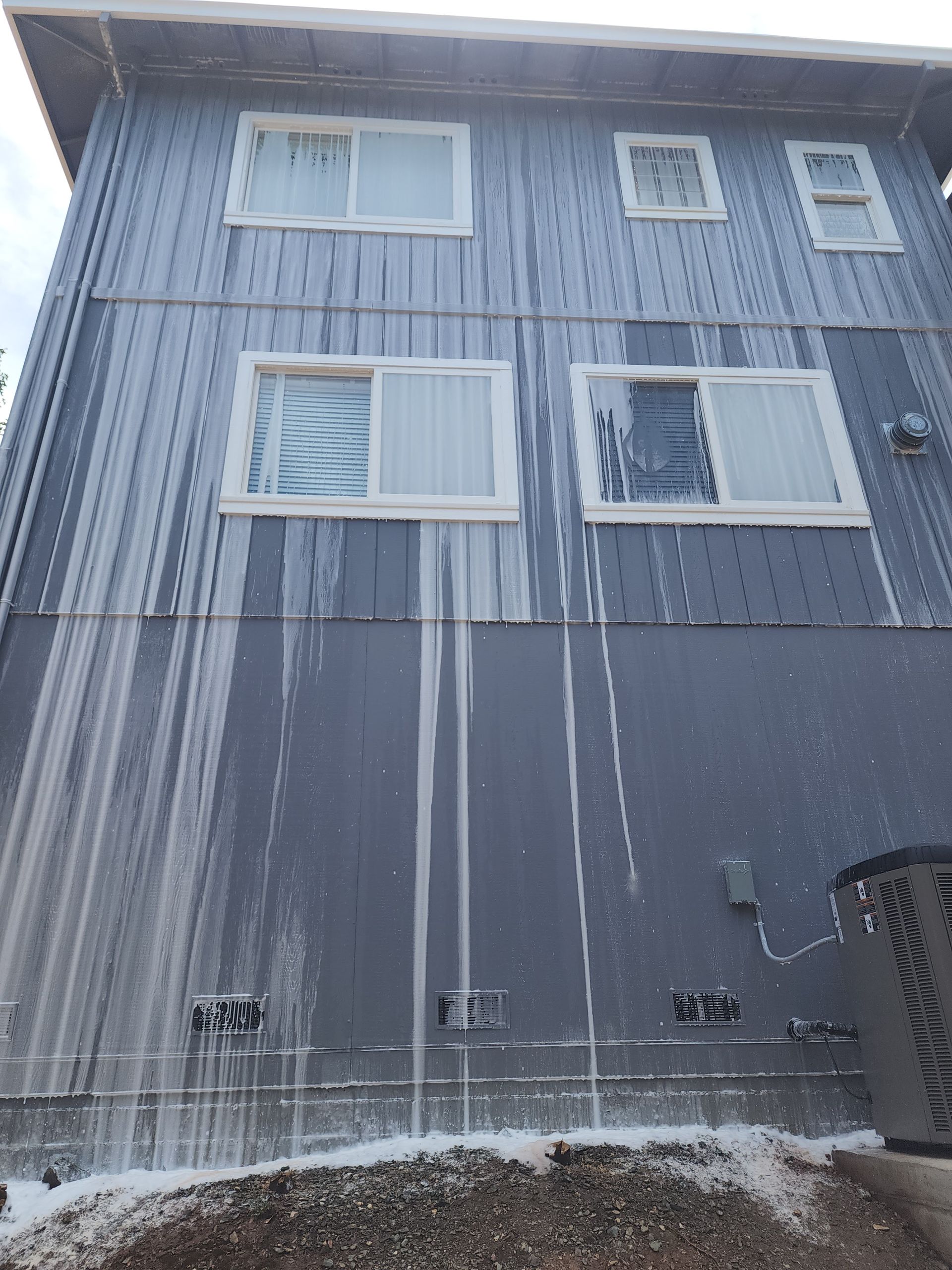 A large building with a lot of windows is covered in snow.