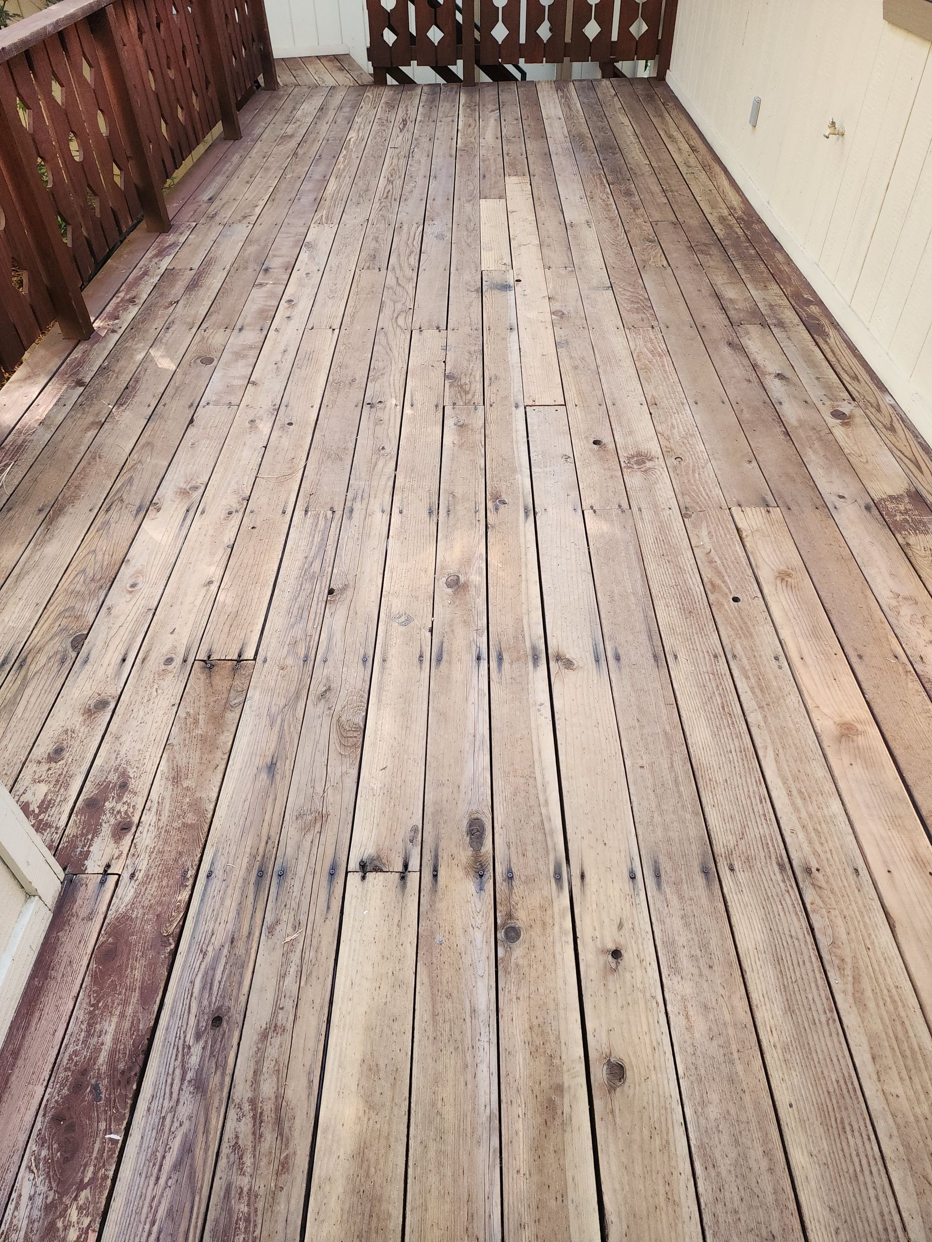 A wooden deck with a fence in the background