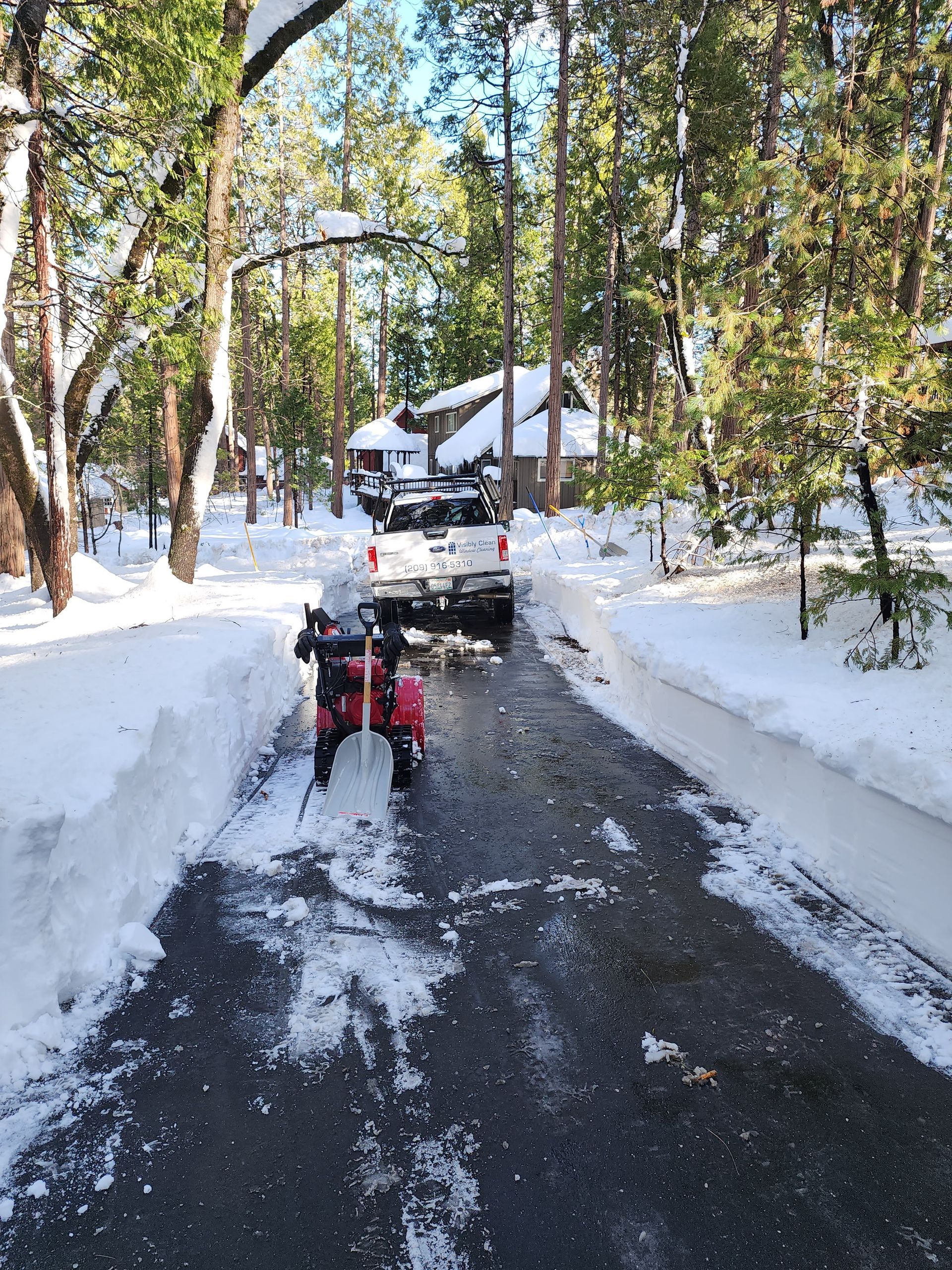 A man is standing on a ladder in front of a large house.