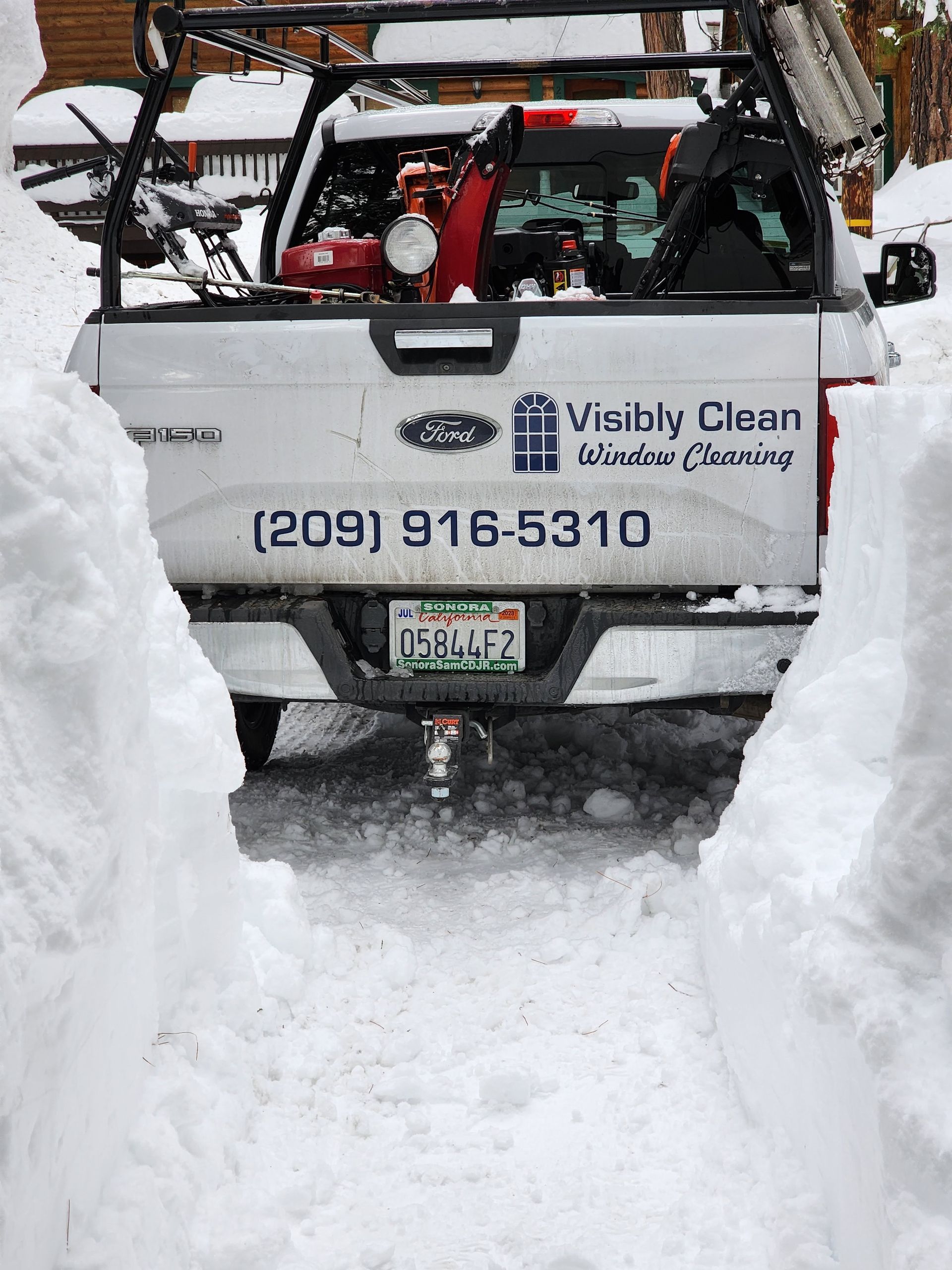 A man and a woman are working on a dishwasher in a kitchen.
