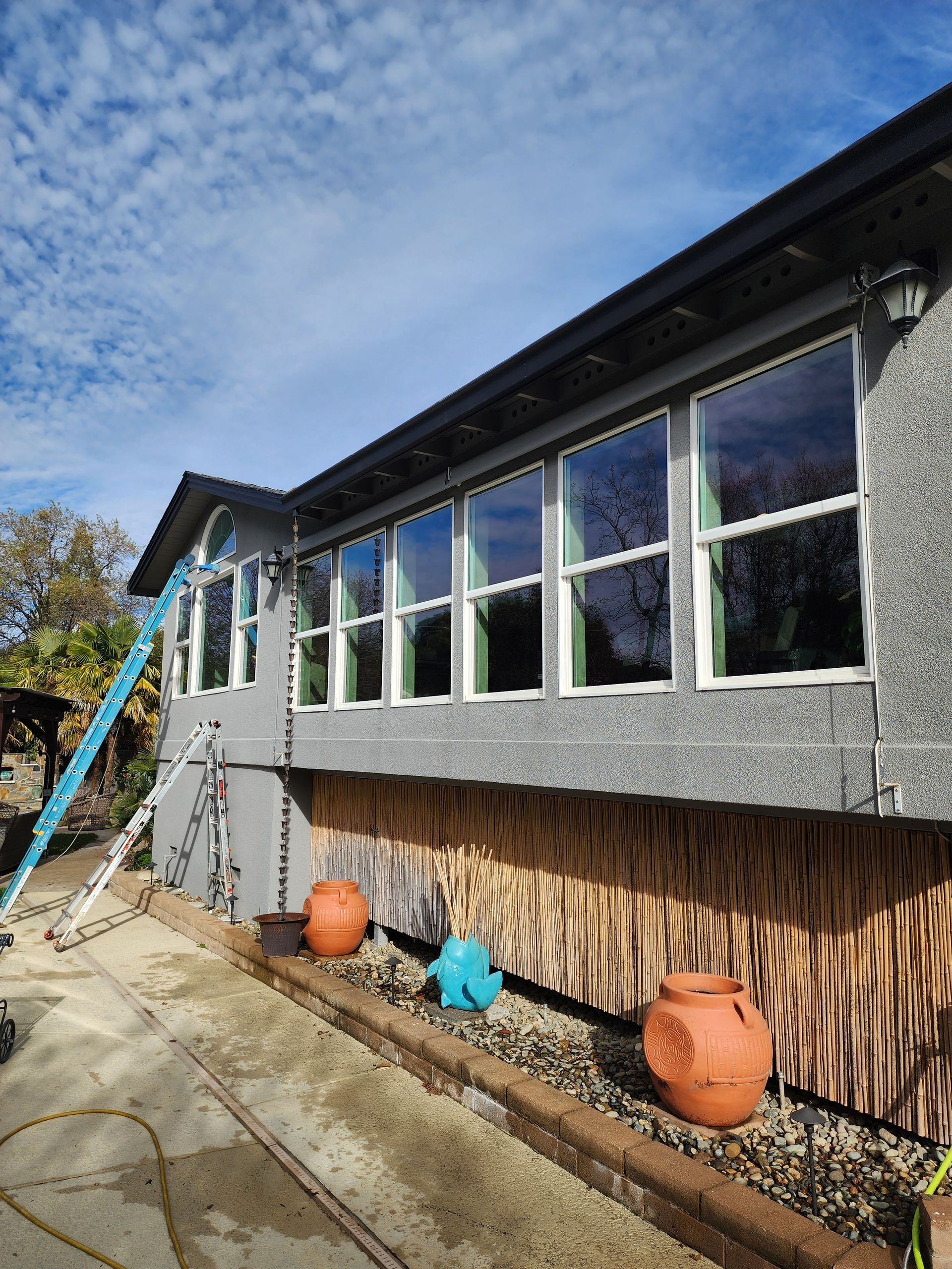 A house with a lot of windows is being painted