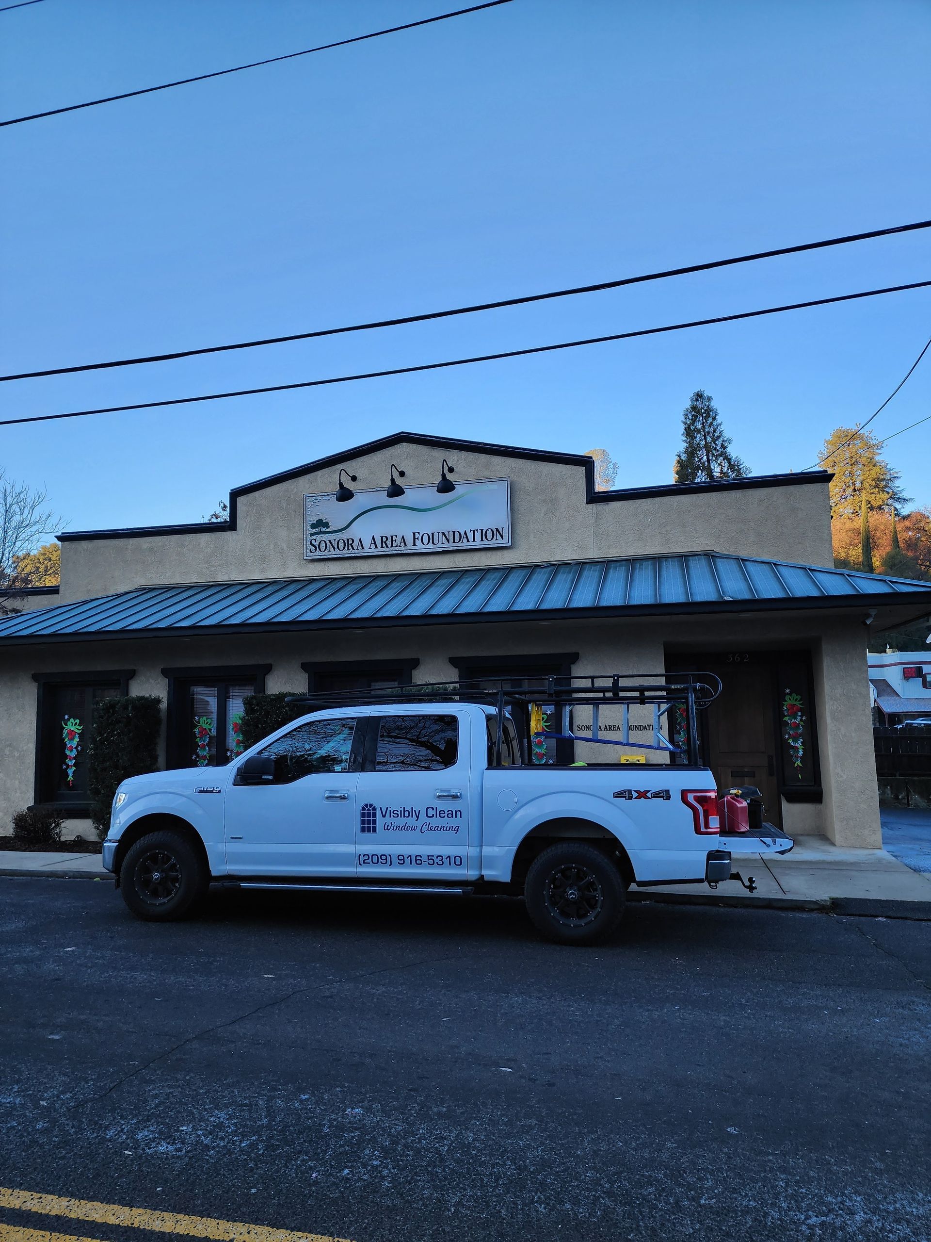 A white truck is parked in front of a building.