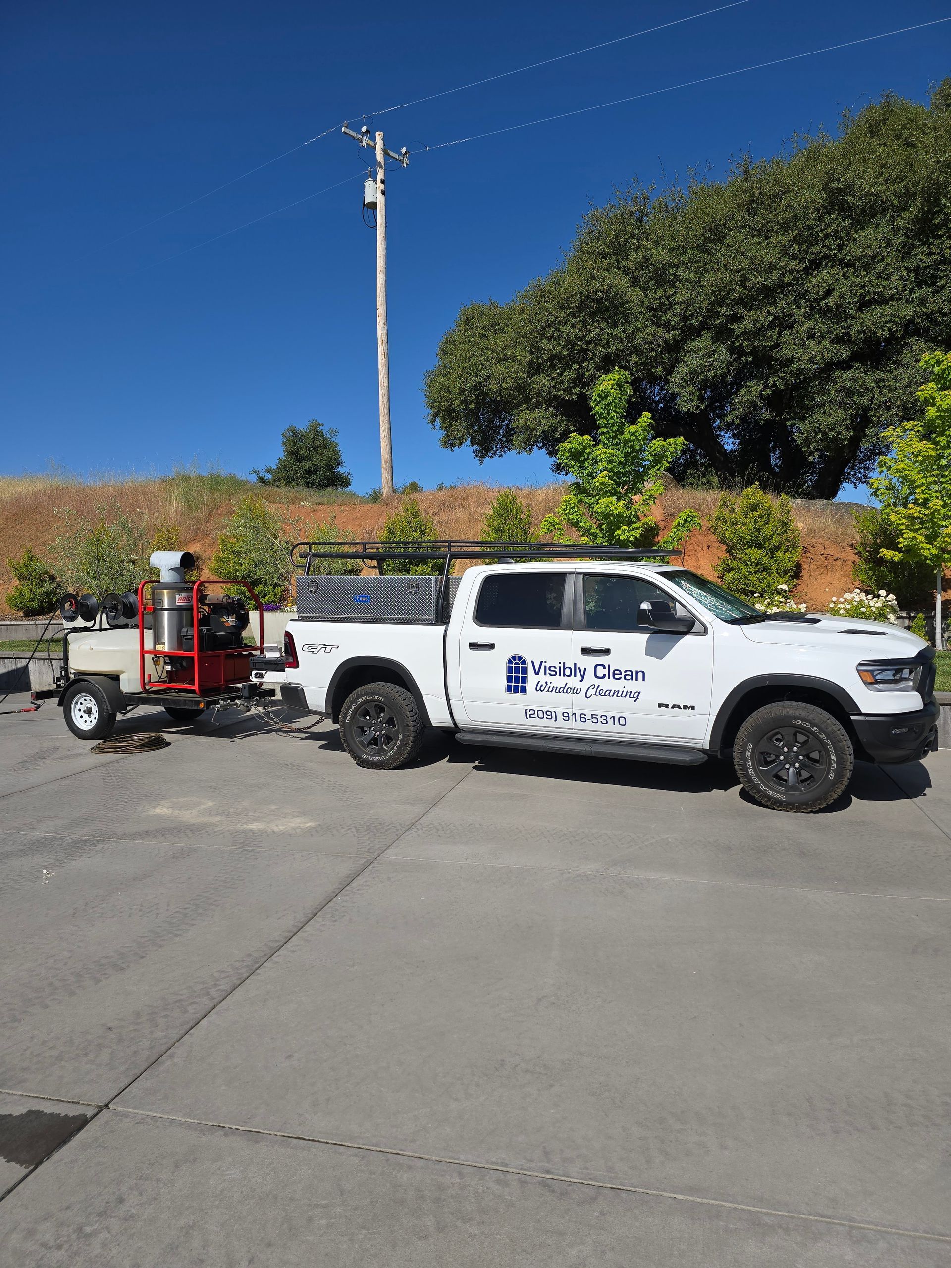A white truck with a trailer attached to it is parked in a parking lot.