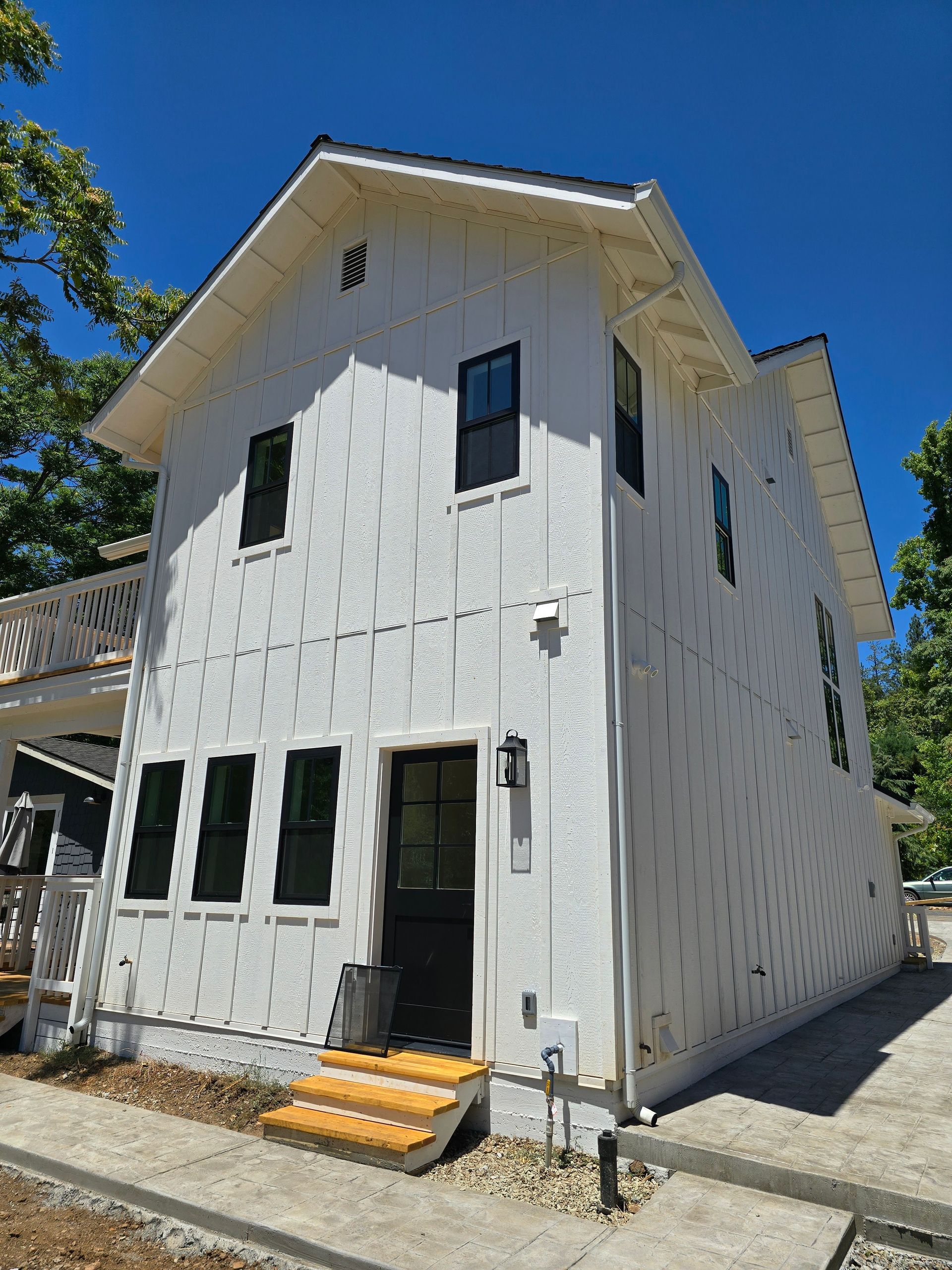 A white house with black windows is being built.