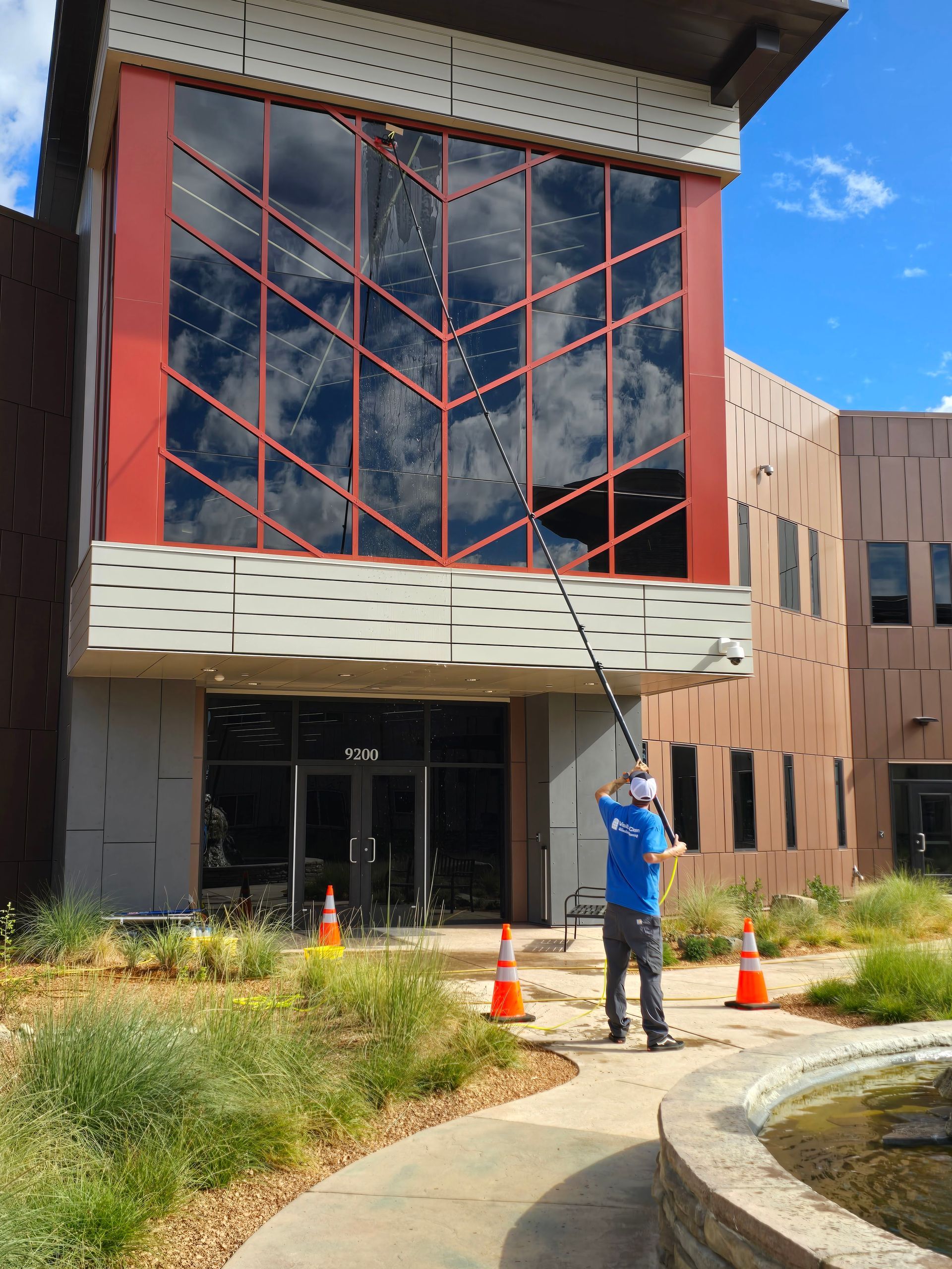 A man is cleaning the windows of a large building