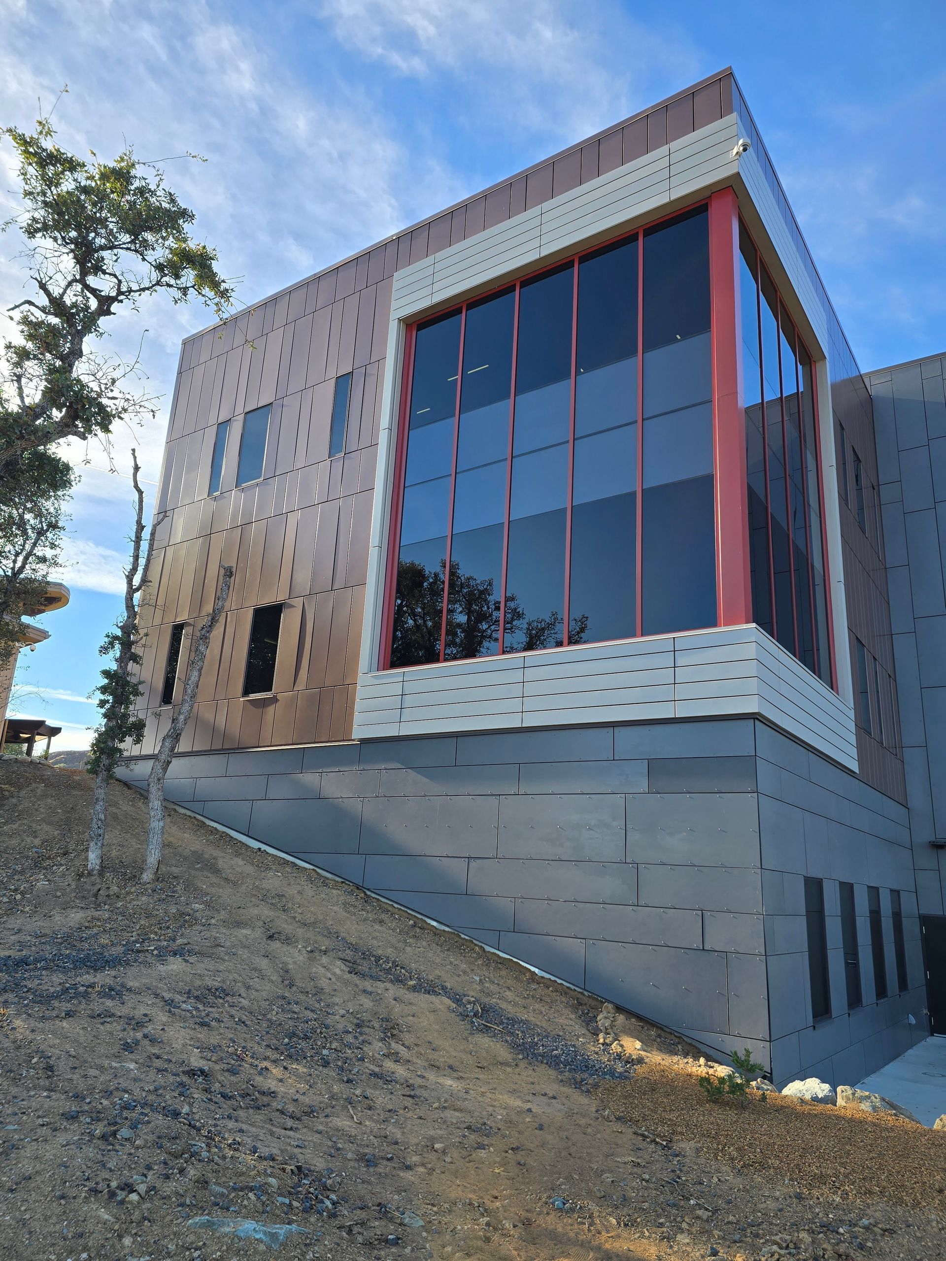 A large building with a lot of windows is sitting on top of a hill.