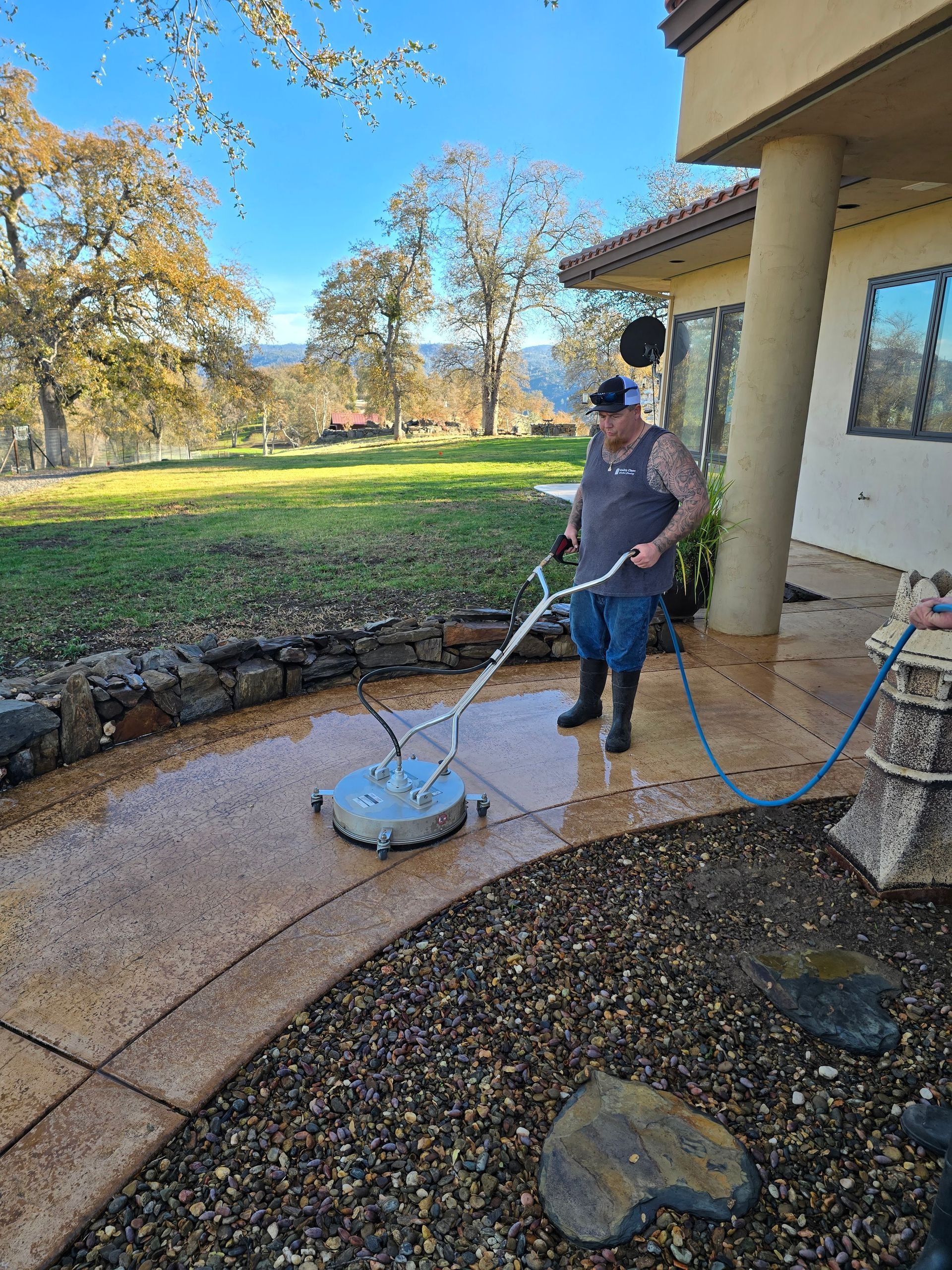 A man is cleaning a patio with a machine.