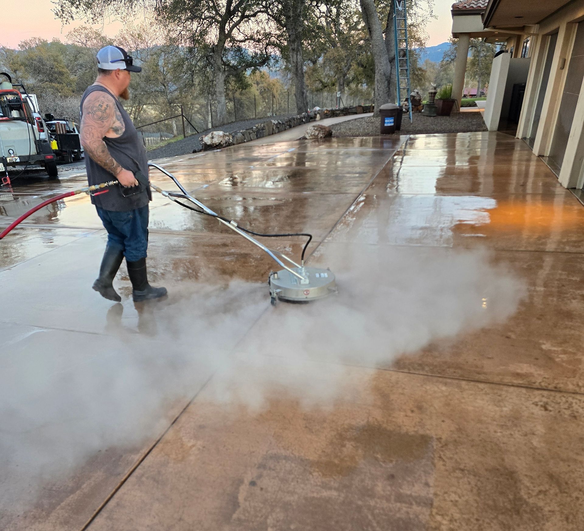 A man is cleaning a store window with a high pressure washer.