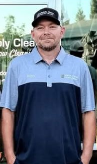 A man in a blue t-shirt is smiling and looking up.