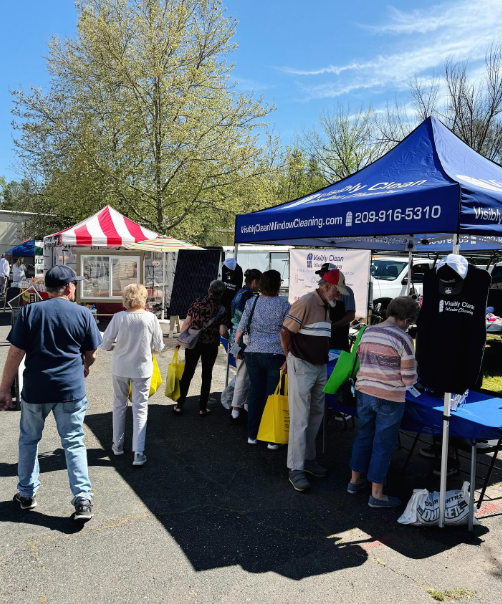 A group of people are gathered under a blue tent with the number 8210 on it