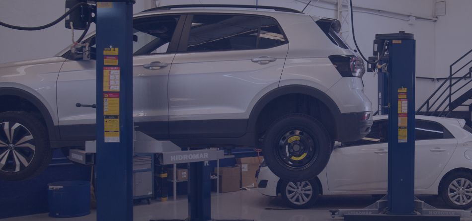 Um carro está sendo içado em um elevador em uma garagem.