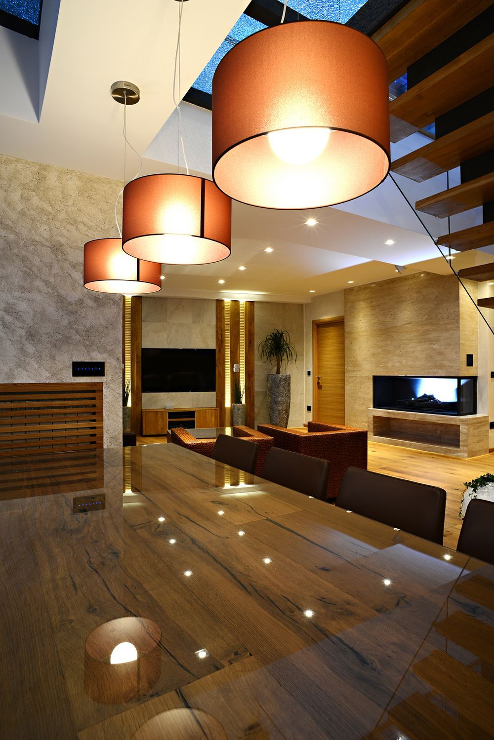 Dining room with large wooden table, pendant lights, and modern decor. Dining room with large wooden table, pendant lights, and modern decor.